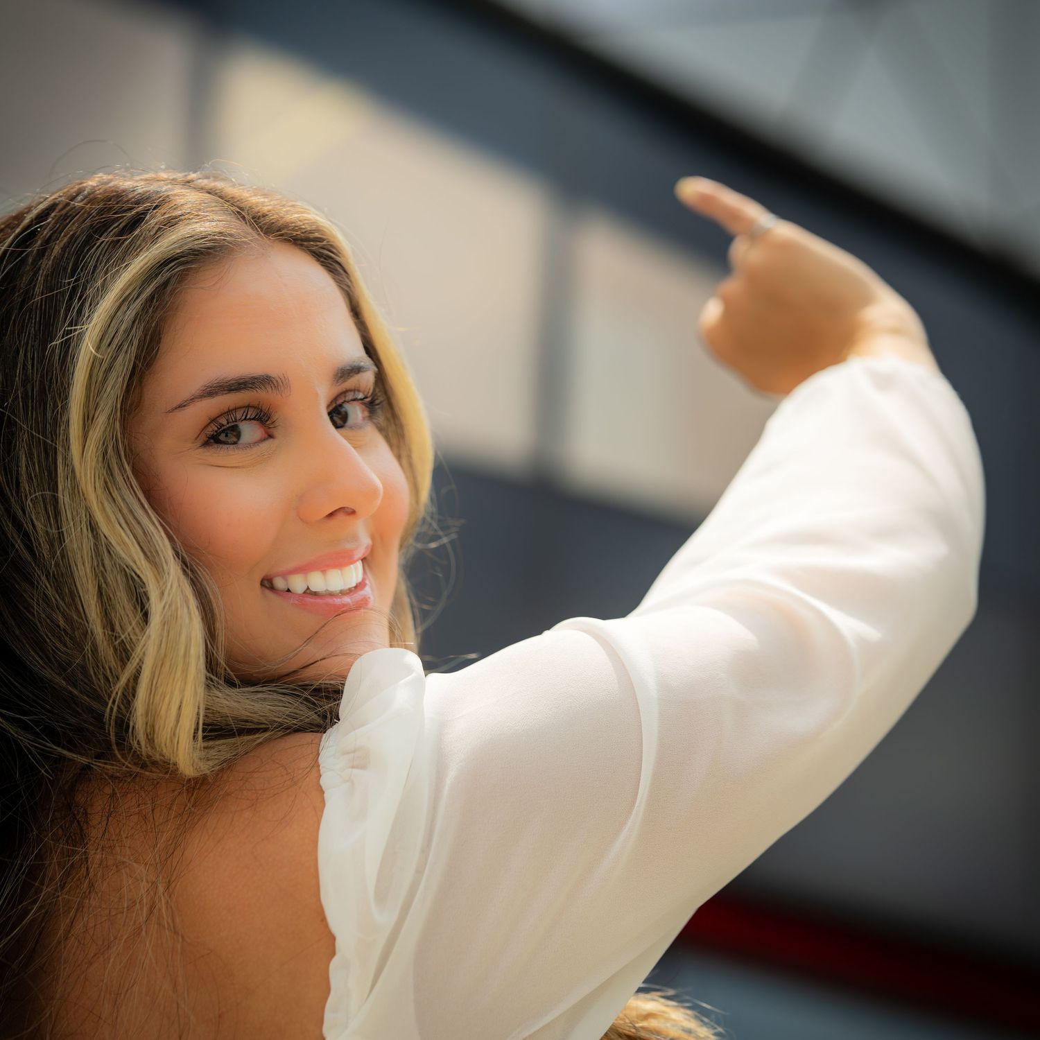 Close up portrait of a person in a white top against blurred background.