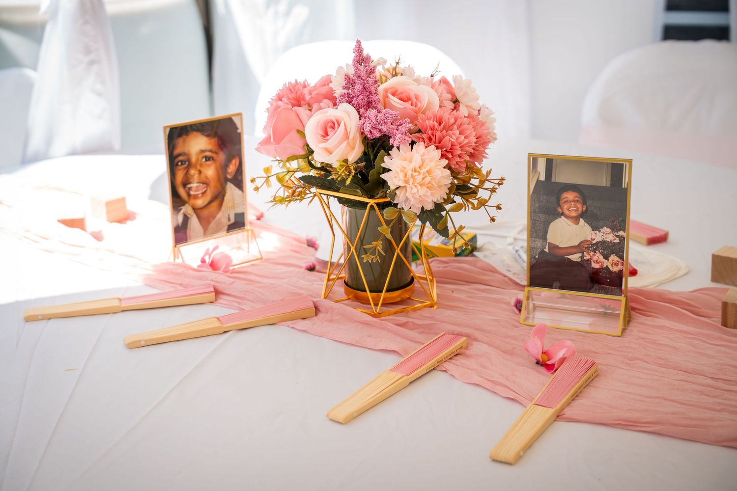 Baby shower setup featuring pink decor, floral arrangements, and activity stations.