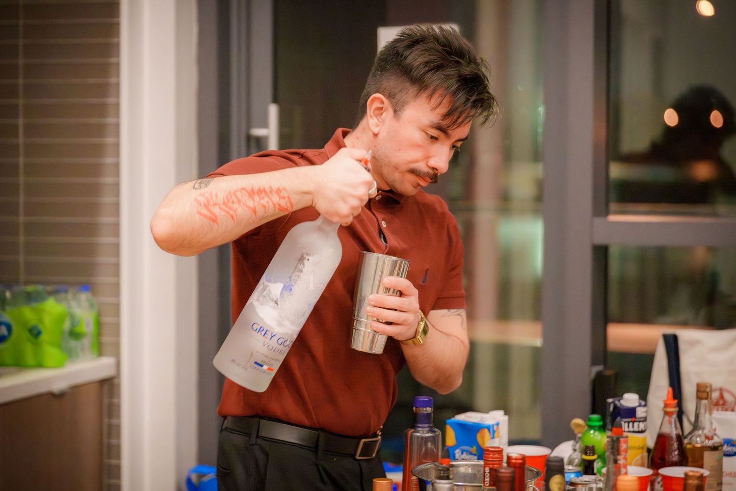 Someone taking a drink at an indoor party with ambient lighting.