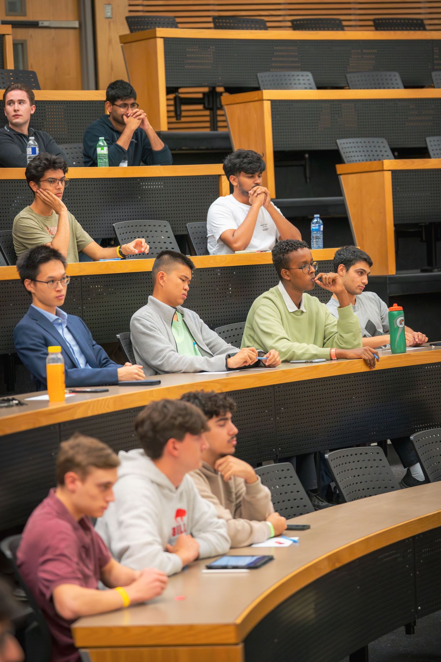 Students seated in tiered lecture hall seating during an academic presentation or event.