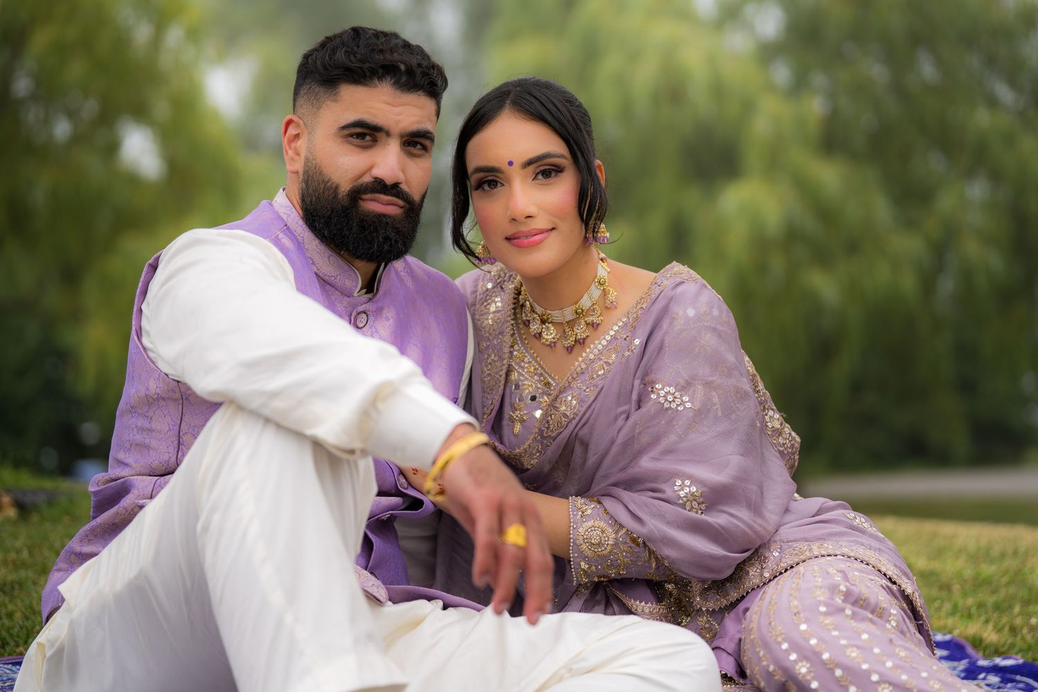 Elegant outdoor portrait session featuring couple in coordinated purple and white ethnic wear.