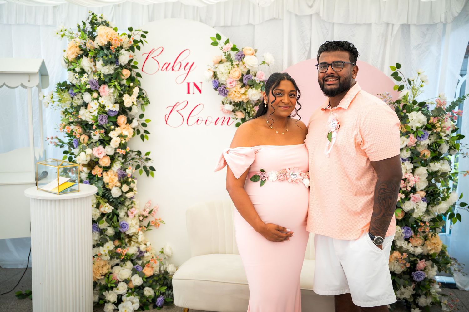 Beautifully decorated event space with floral archways and pink accents.