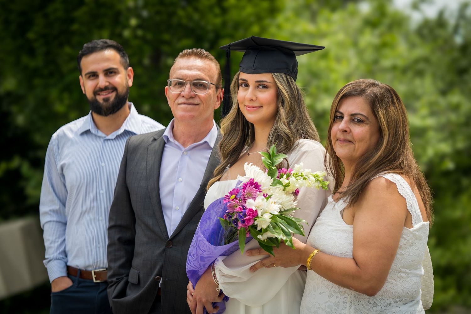 Outdoor graduation celebration photos with colorful flowers and formal attire.