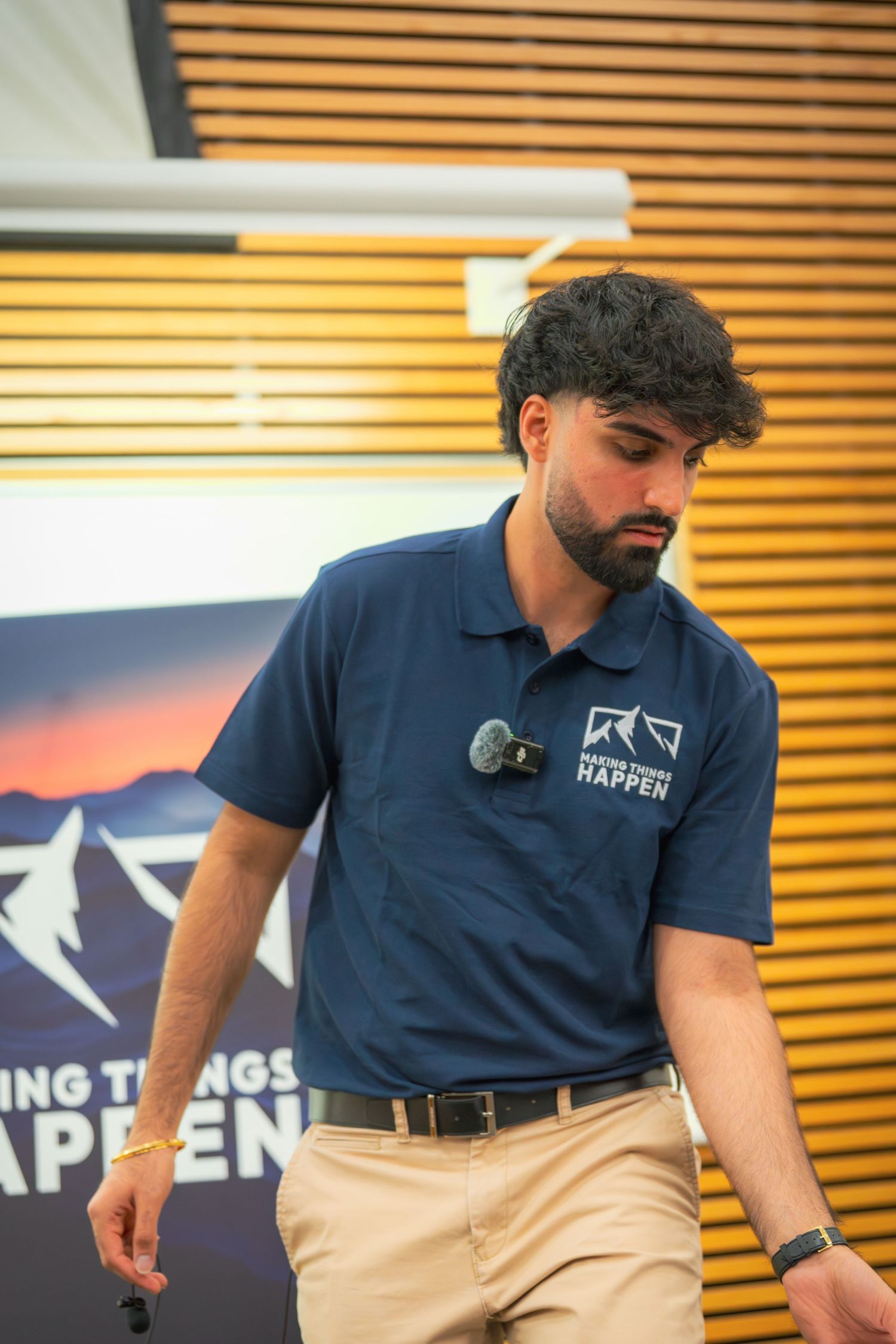 Close-up of navy polo shirt with mountain logo during business presentation.