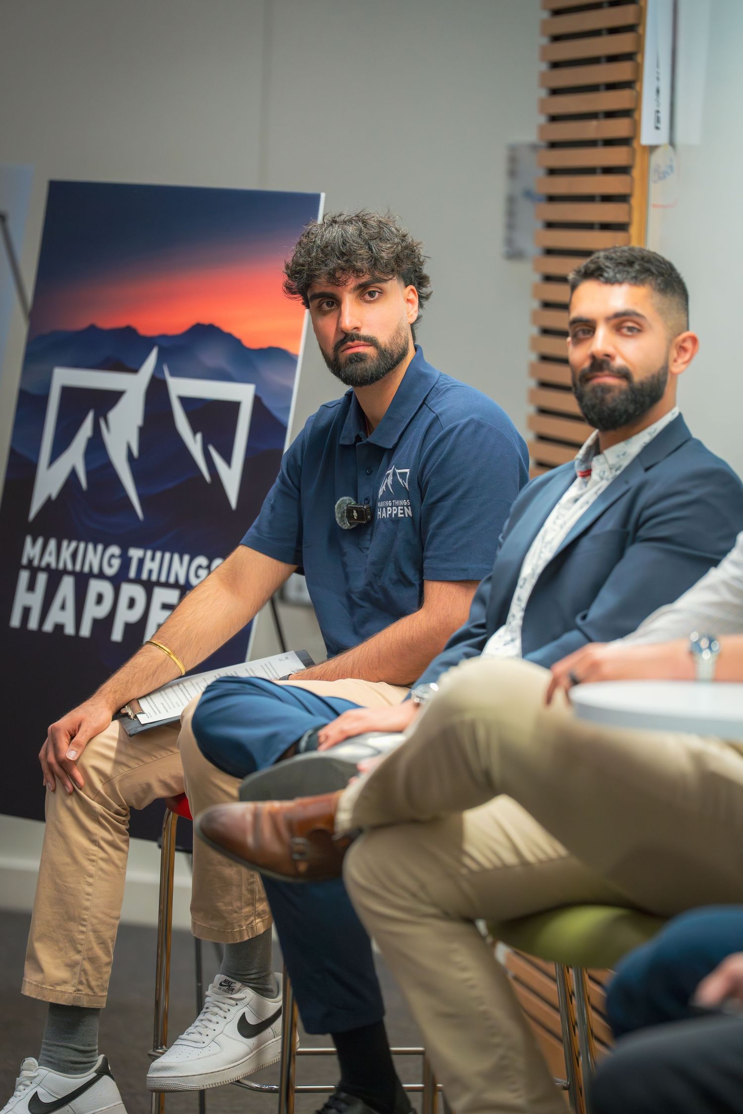 Business professionals in casual attire participate in panel discussion.