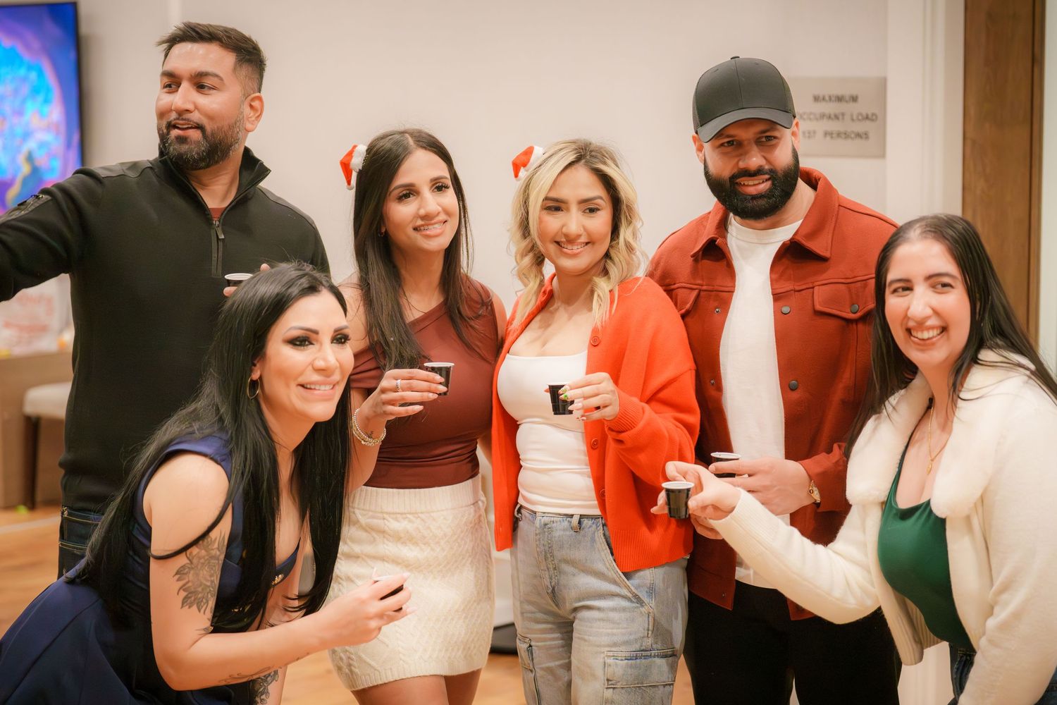 Group of party guests smiling and posing together for photos.