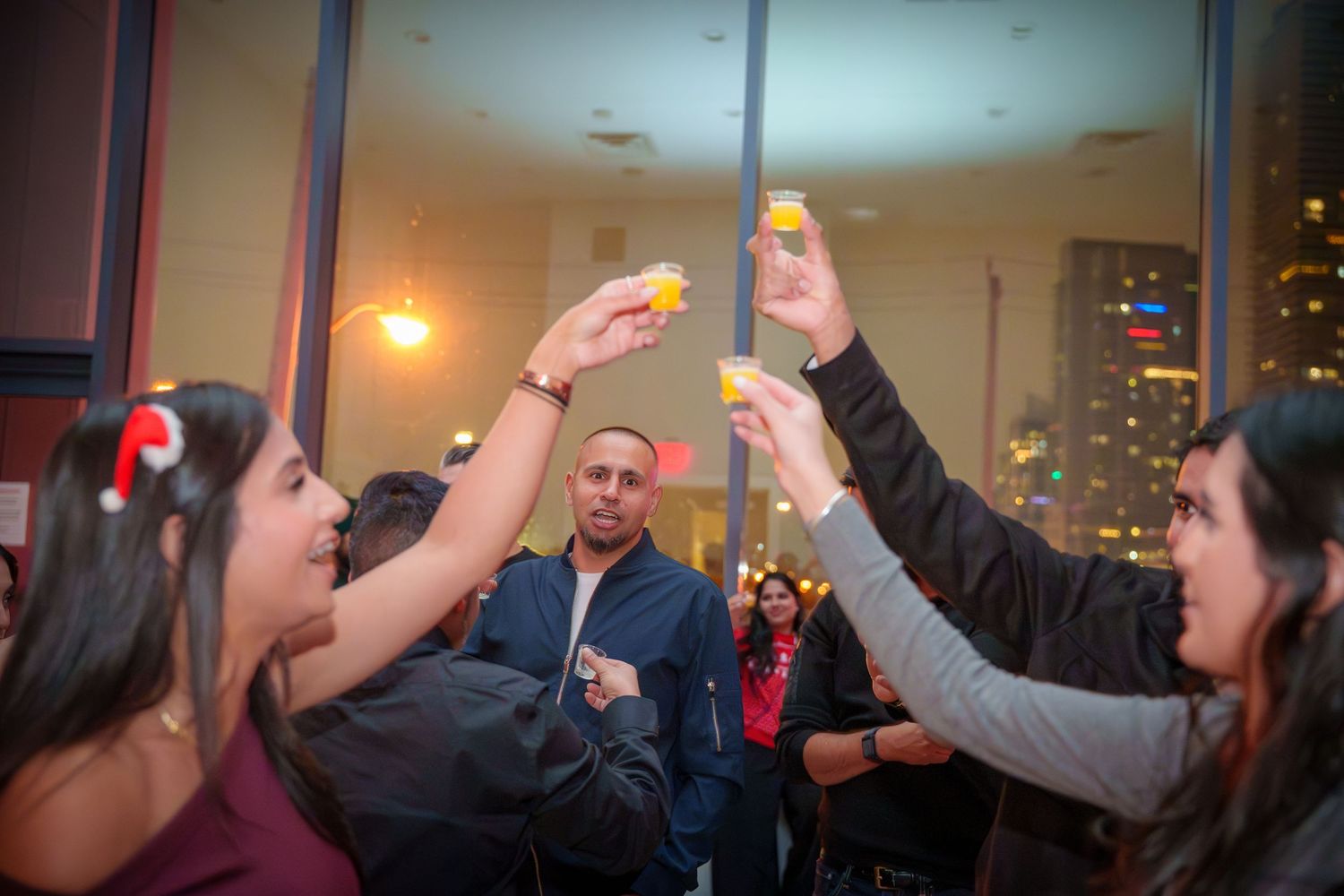 Group of friends raising their glasses in a celebratory toast at a party.