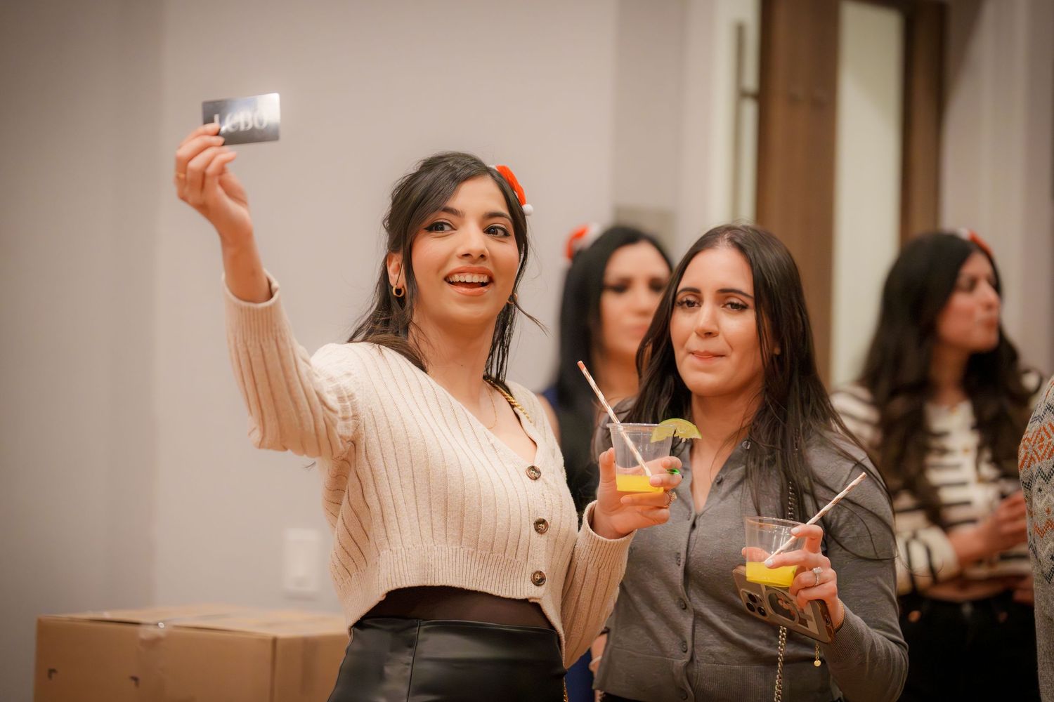 Friends raising drinks and celebrating at an indoor social gathering.
