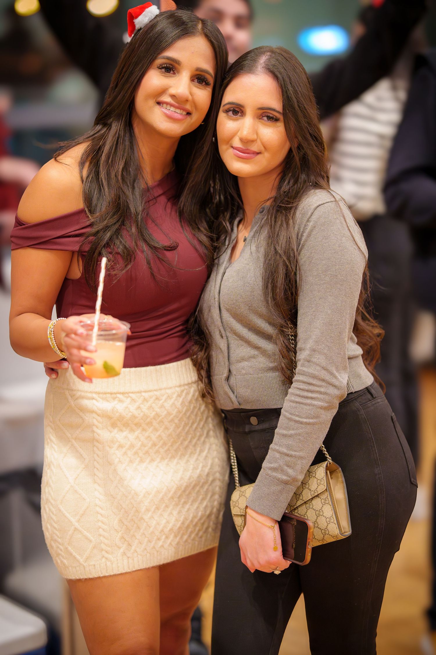 Friends posing together at a holiday party wearing casual winter attire.