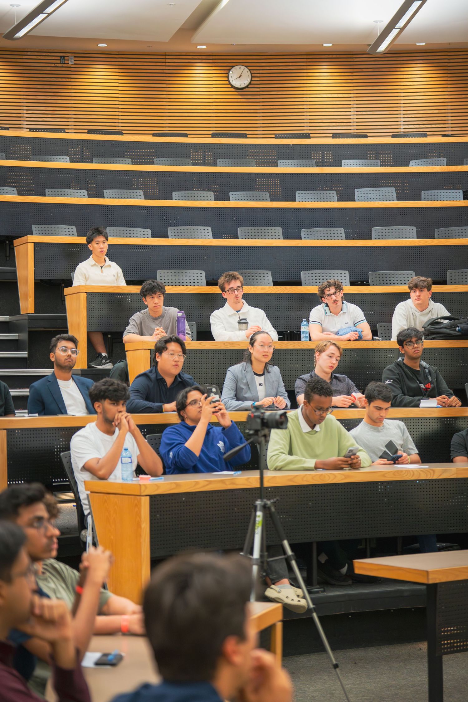 Wide view of a lecture hall filled with engaged students during a presentation.