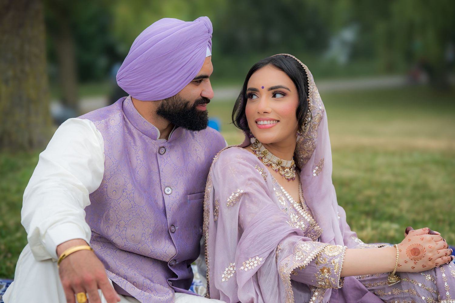 Candid moments between newlyweds wearing traditional Punjabi wedding attire in purple tones.