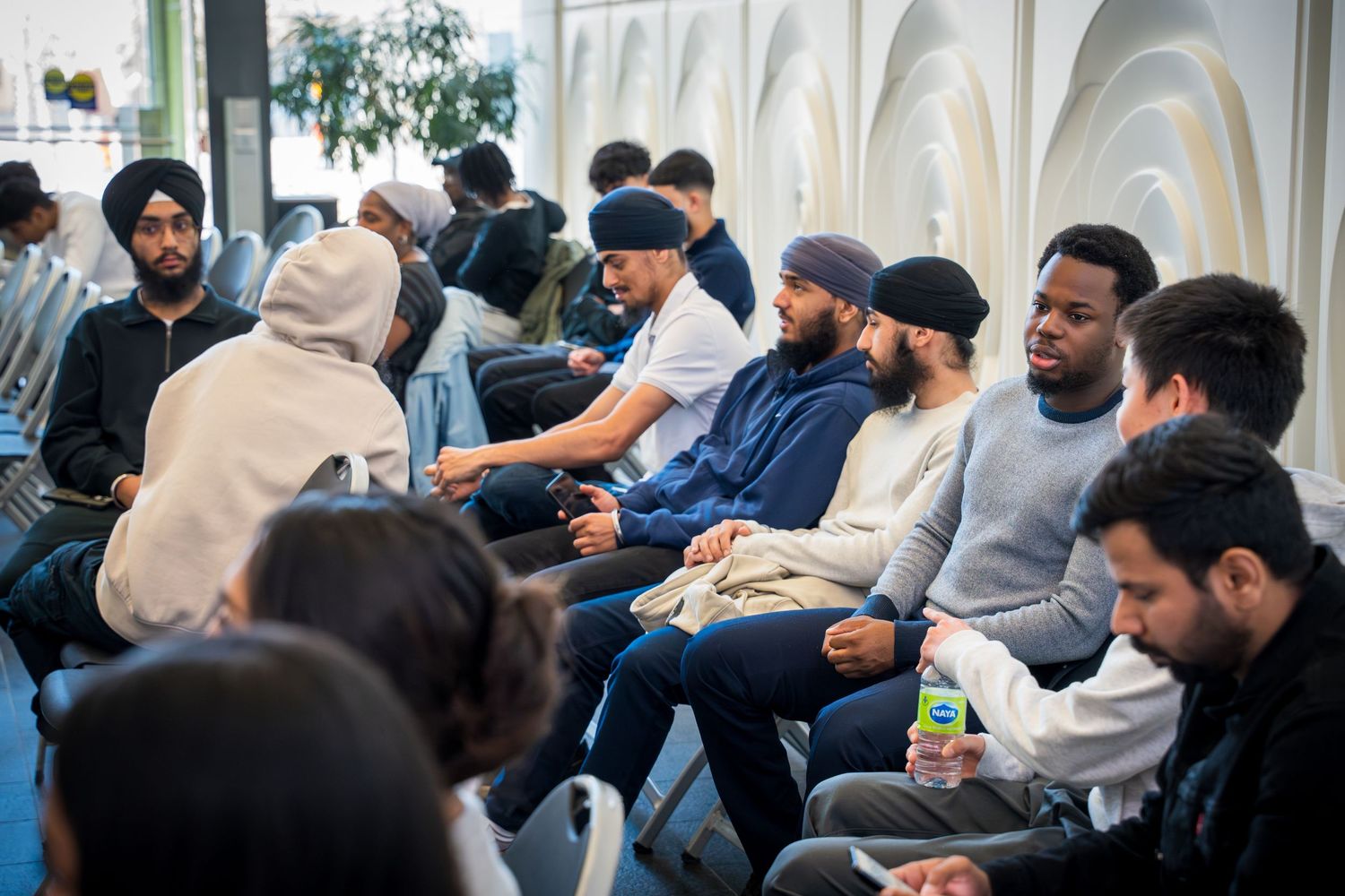 Engaged audience members seated in folding chairs at a professional gathering.