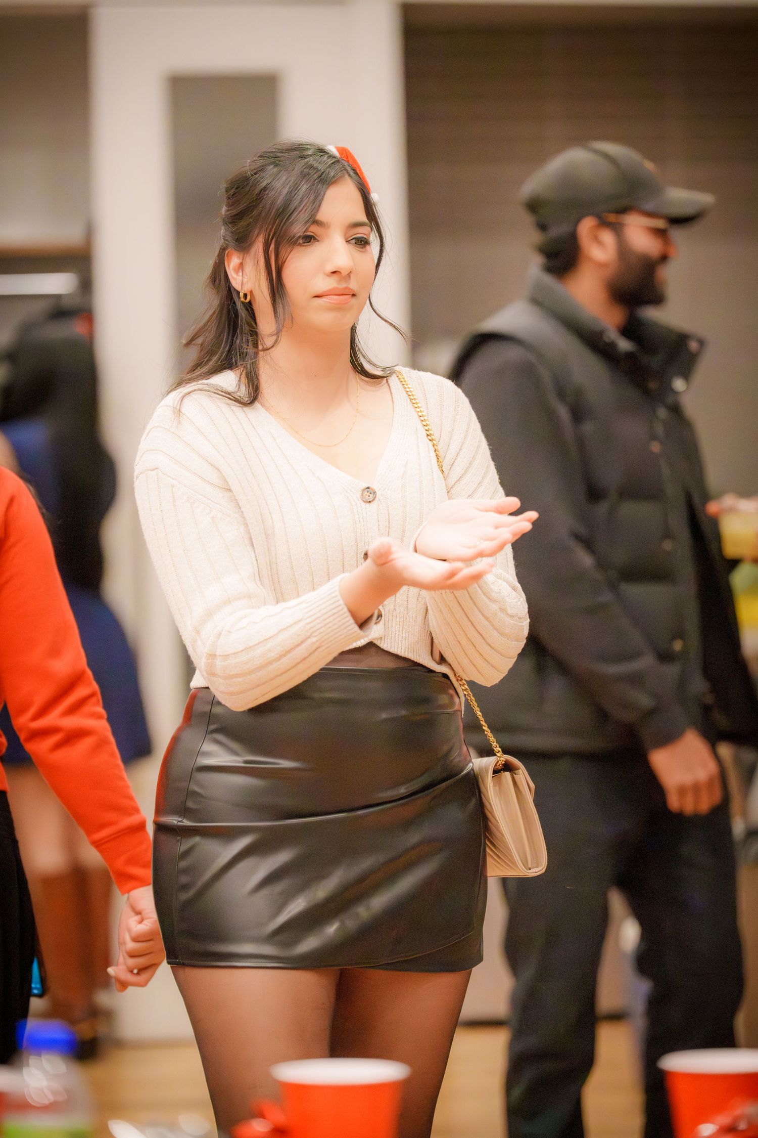 People gathered at an indoor party with red cups and casual attire enjoying social activities.