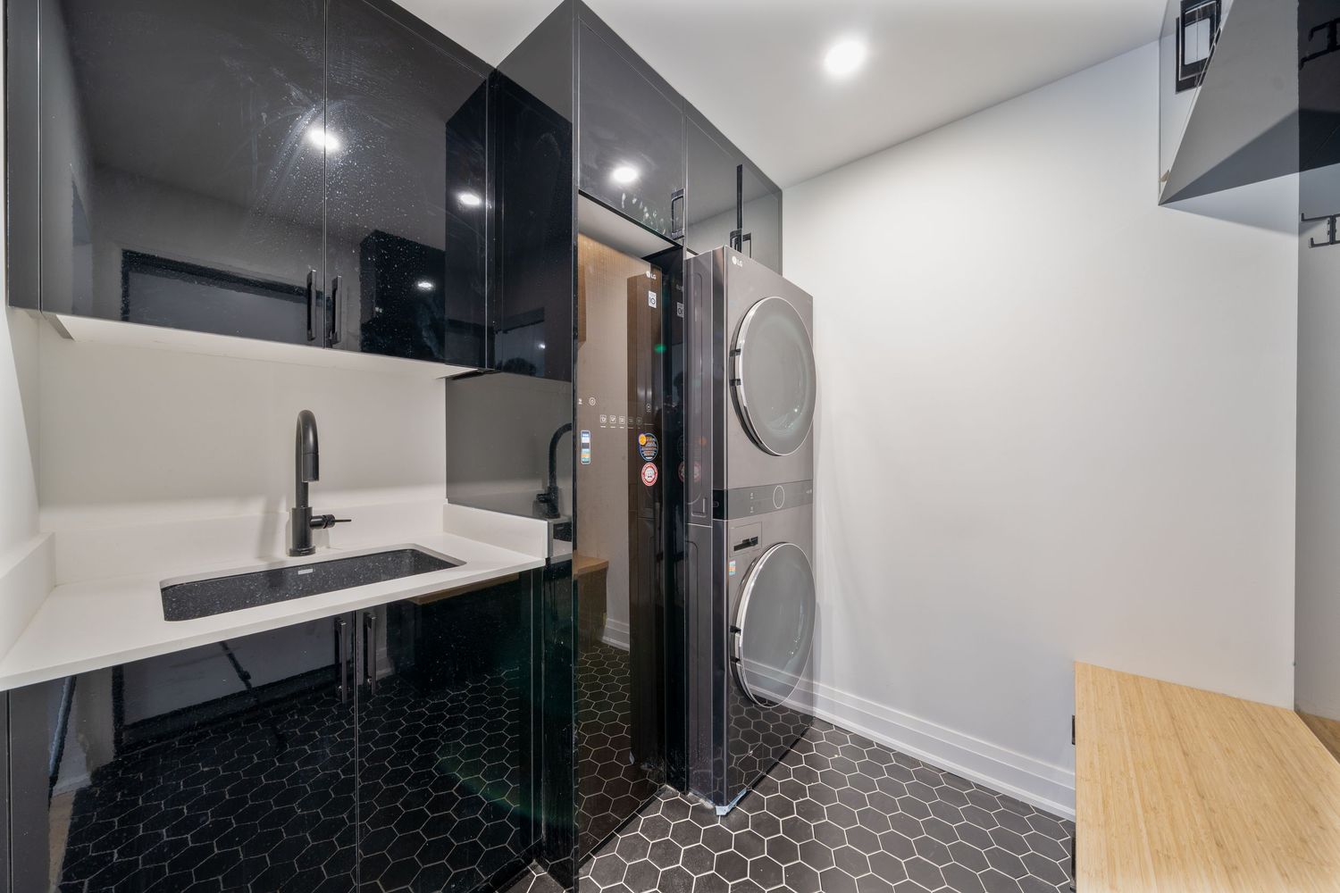 Modern kitchen interior with sleek black and white cabinets, wooden countertops, and stainless steel appliances.