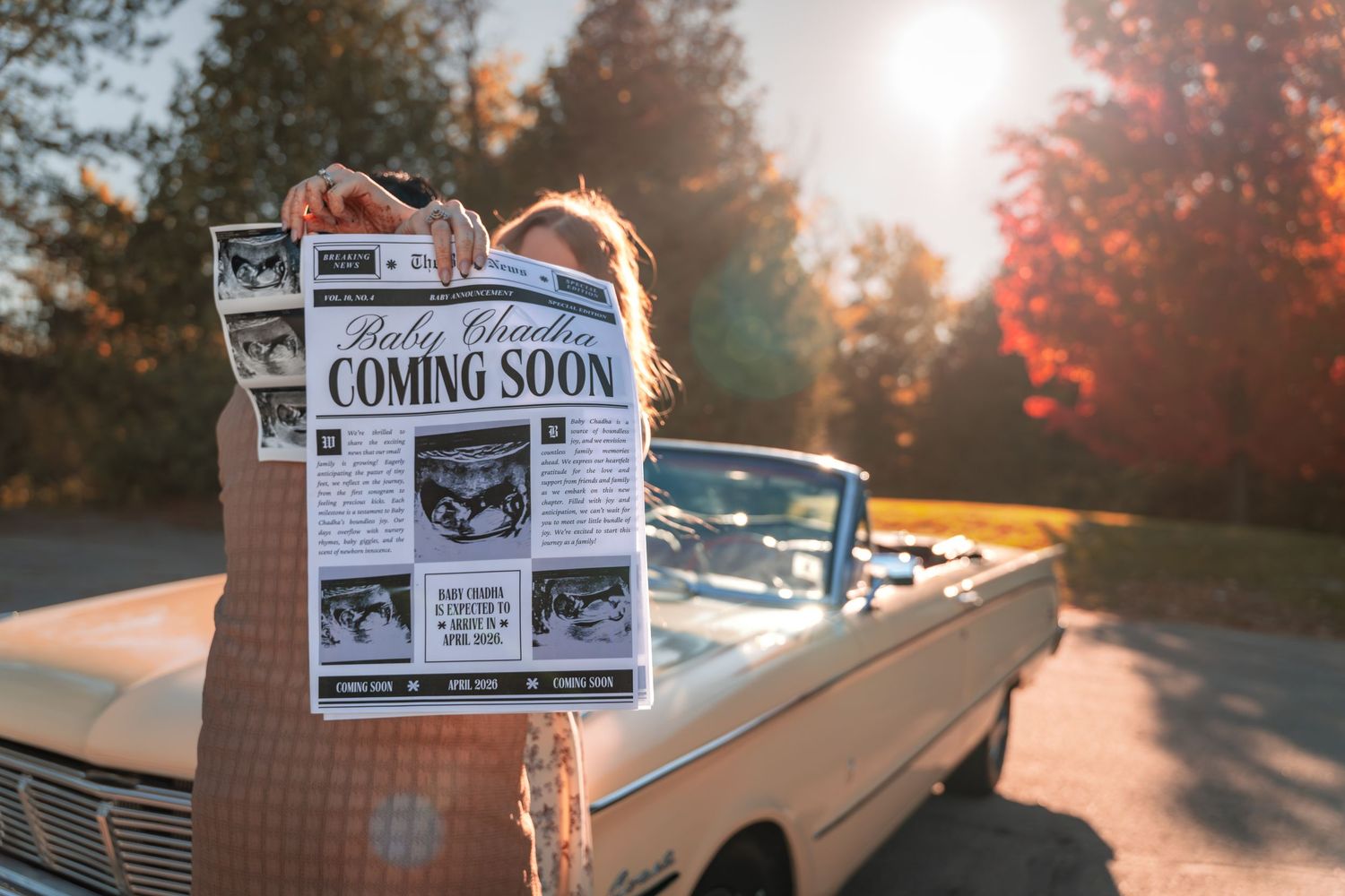 Vintage car parked at sunset with newspaper being held up against warm golden light.