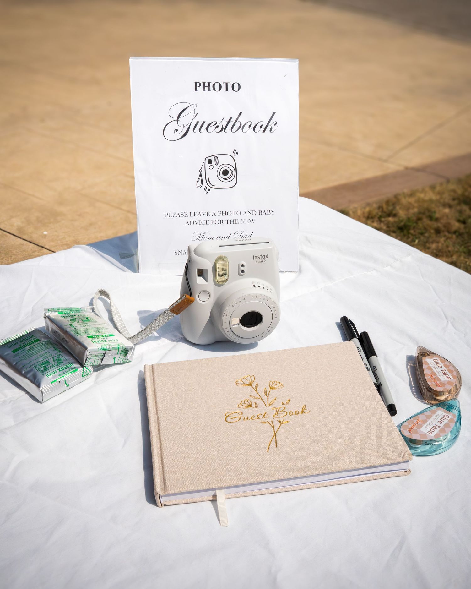 Wedding guestbook and photo station setup with instant camera and decorative elements.