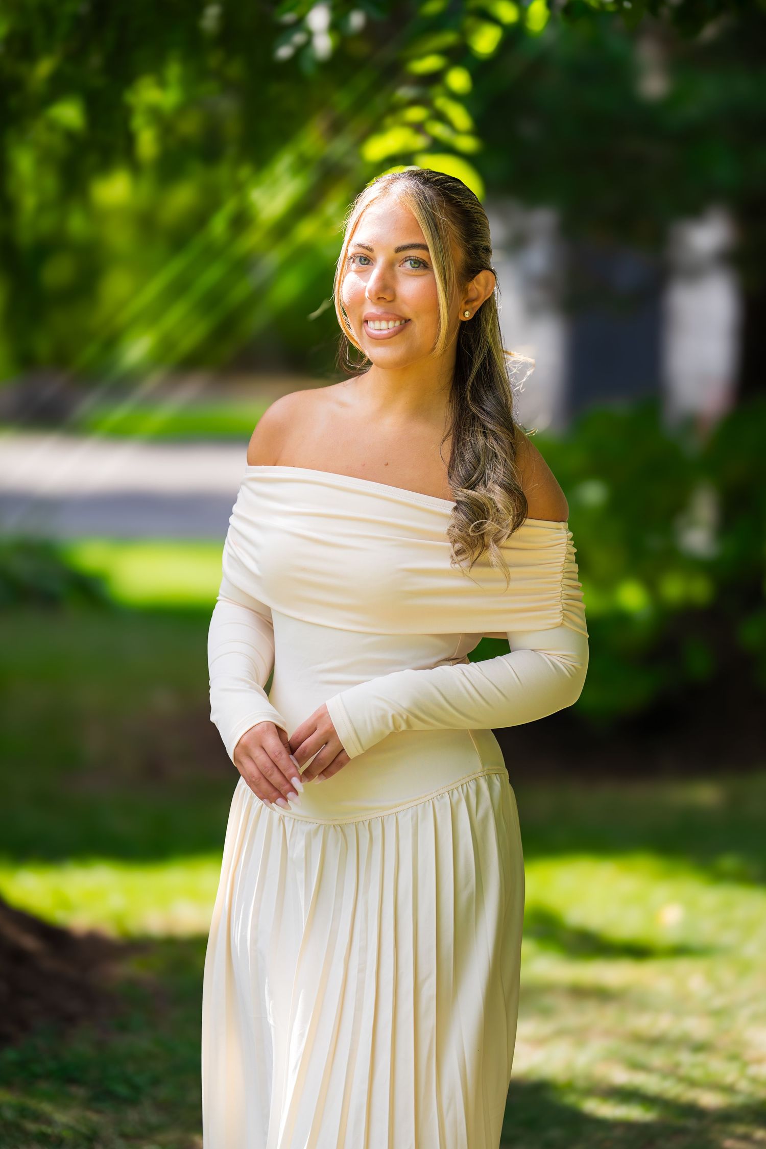 A beautiful off-shoulder cream dress photographed in natural outdoor lighting.