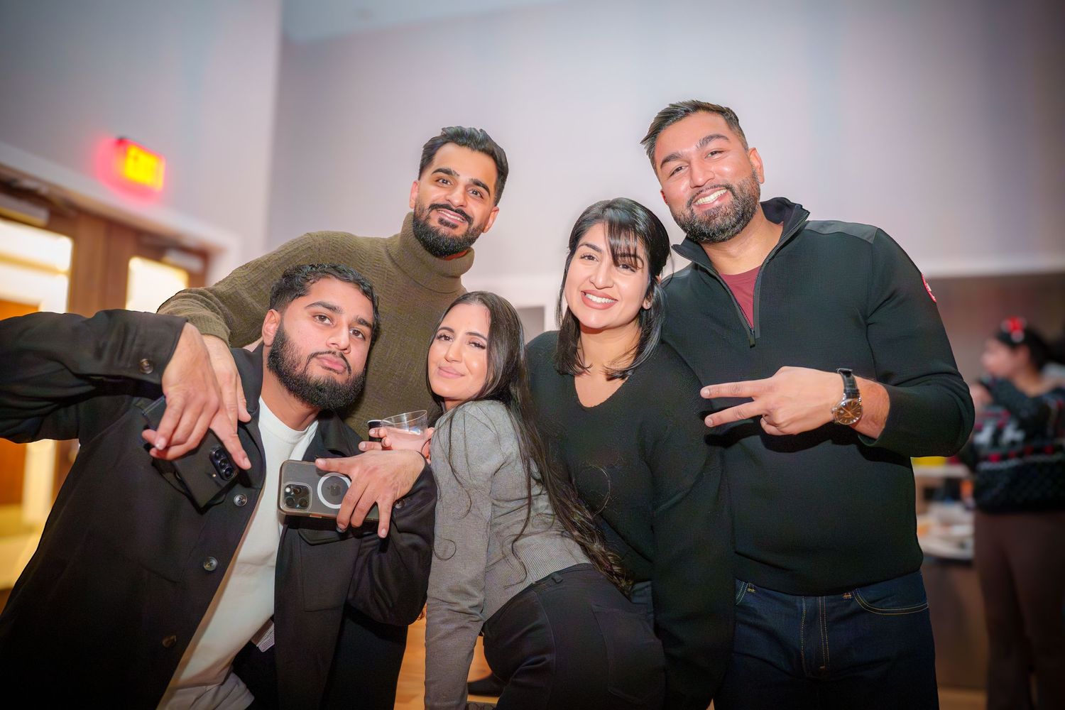 Friends gathering and posing for casual photos at an indoor party.
