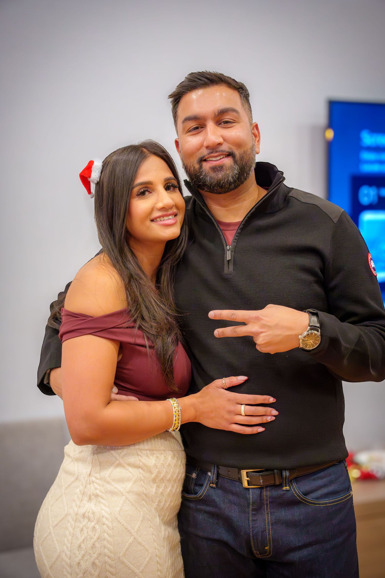 Couple posing together at a party in formal attire.