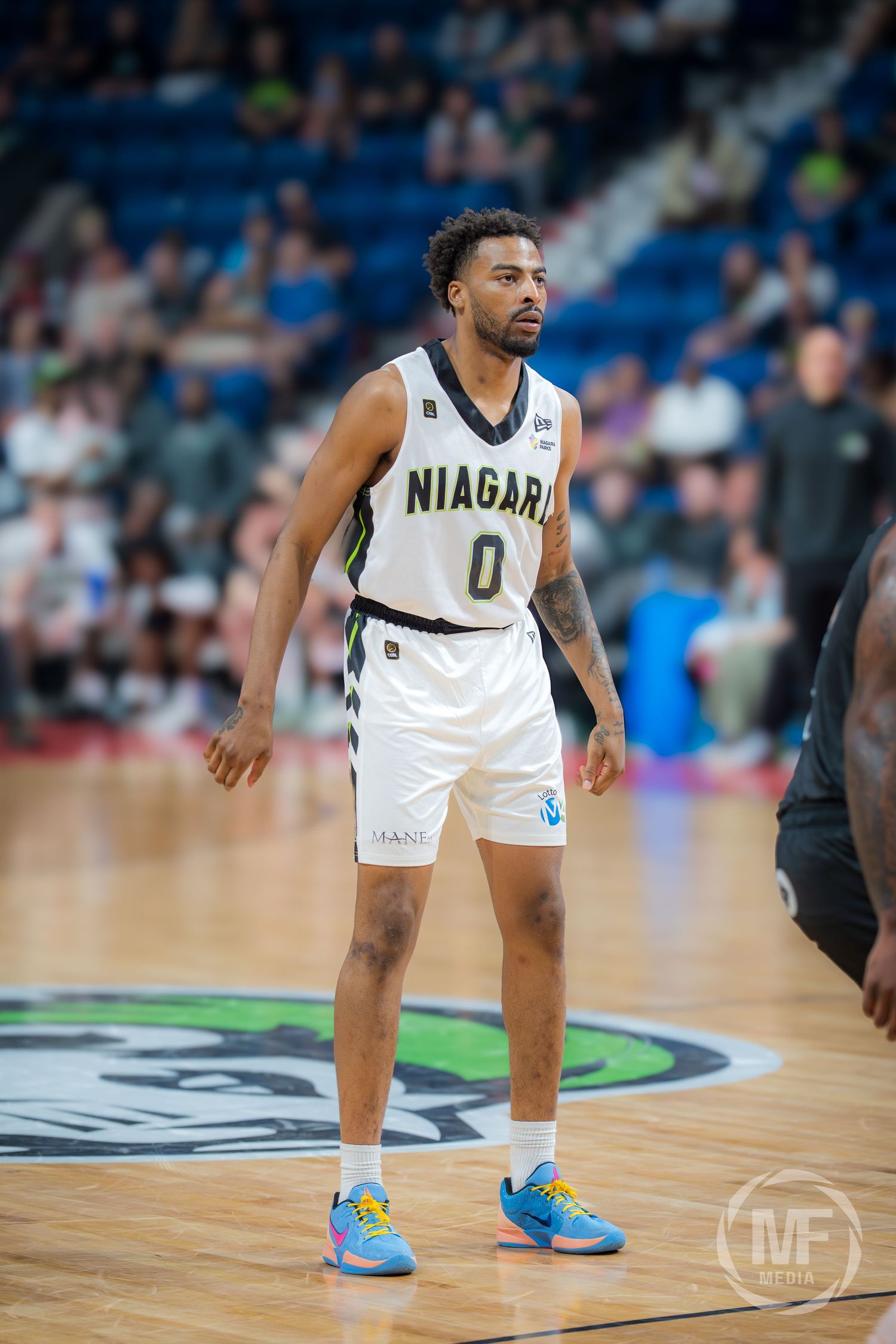 Niagara basketball player wearing number 0 white jersey stands on court during a professional game.
