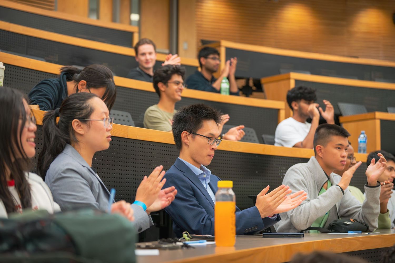 Audience members in a lecture hall engage with content being presented.