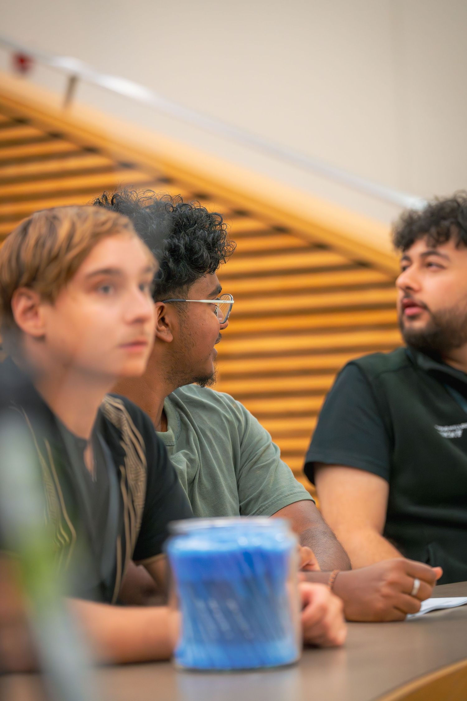 Students sitting in a row at a conference table during an educational discussion.