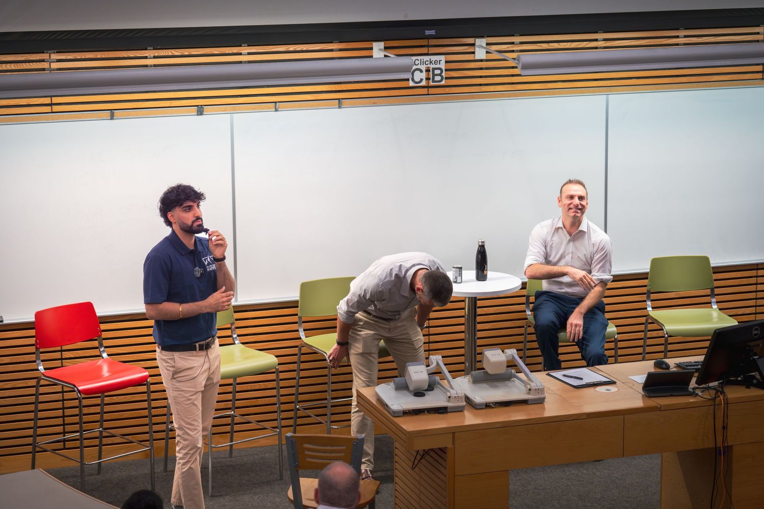 Wide angle view of a modern conference room during a professional presentation.