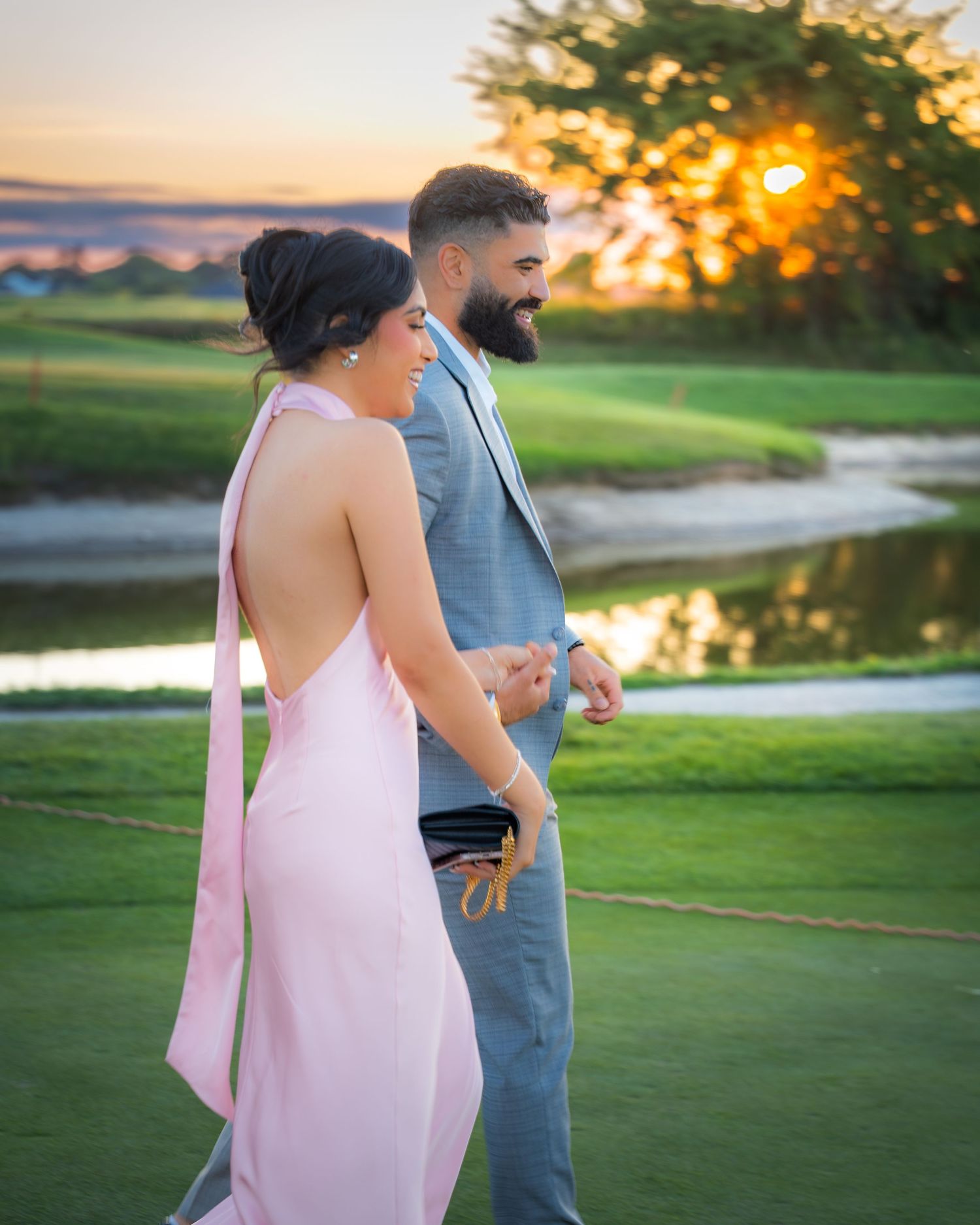 A romantic sunset proposal setup on a golf course with elegant white floral arrangements and candles.