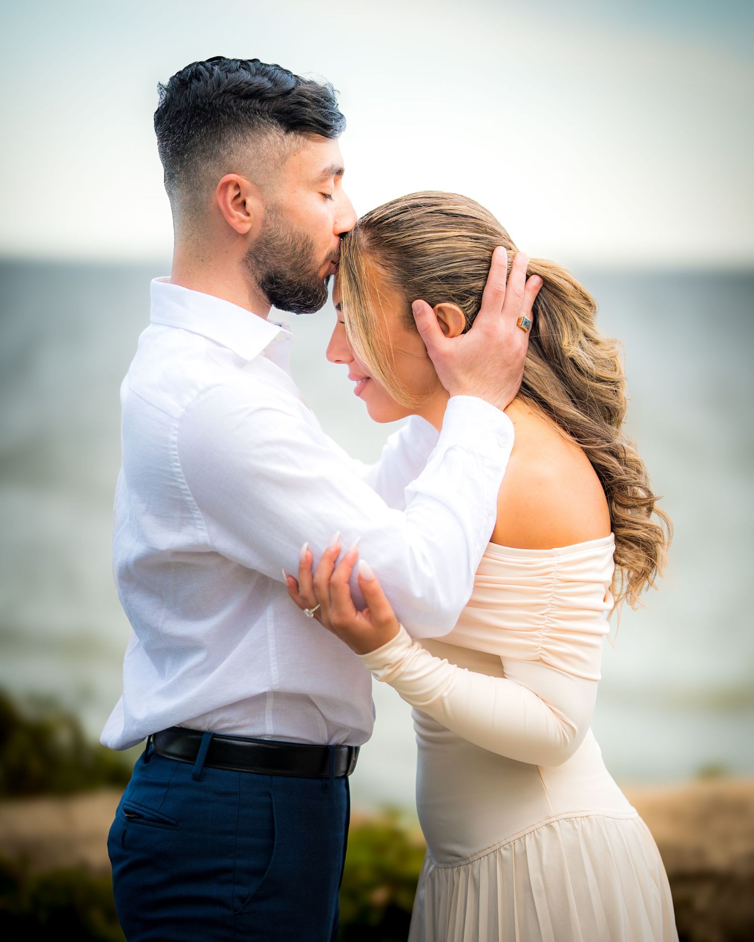 Dancing couple in elegant attire captured in romantic motion against natural backdrop.