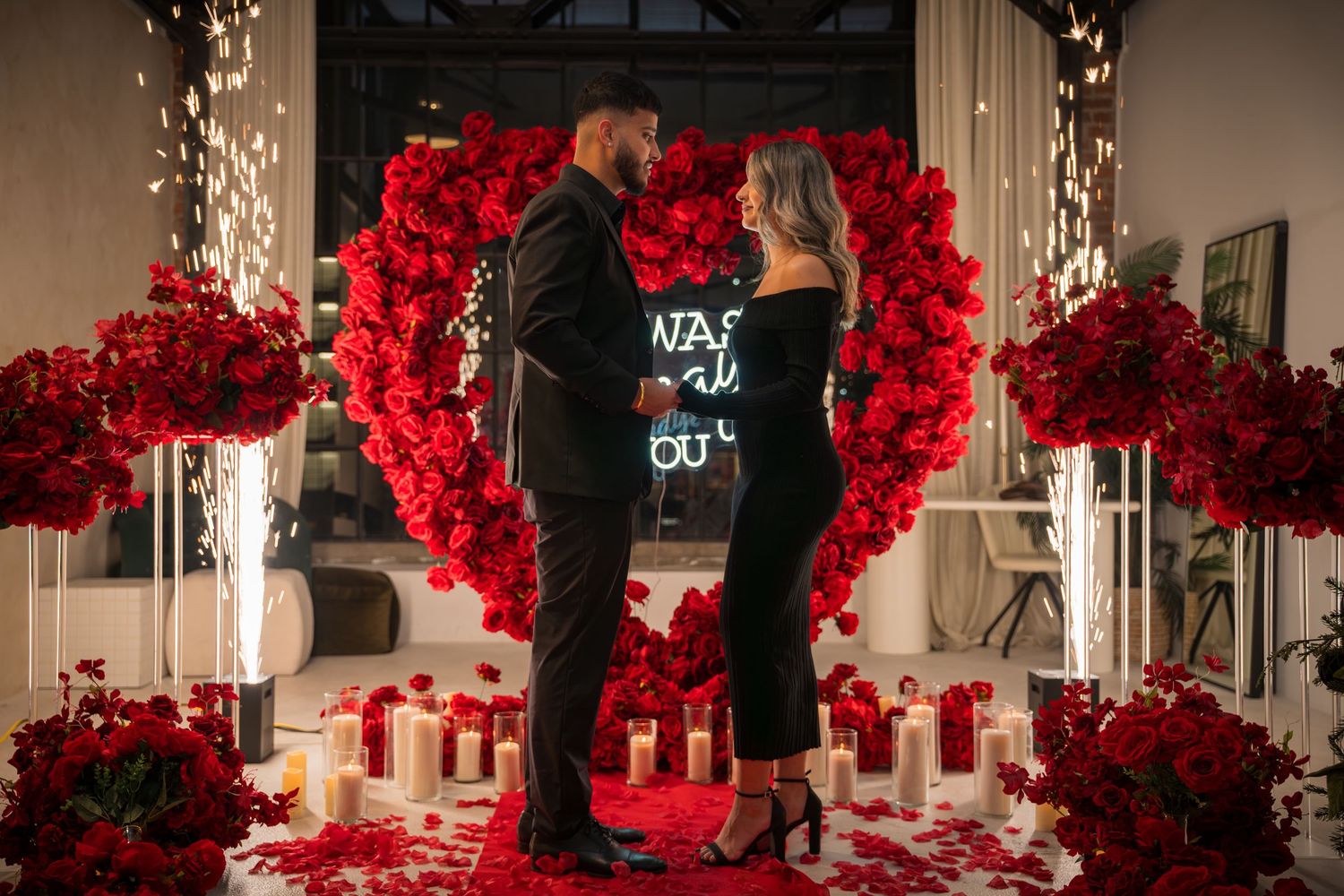 Romantic venue decorated with red rose walls and floor lighting for special occasion.