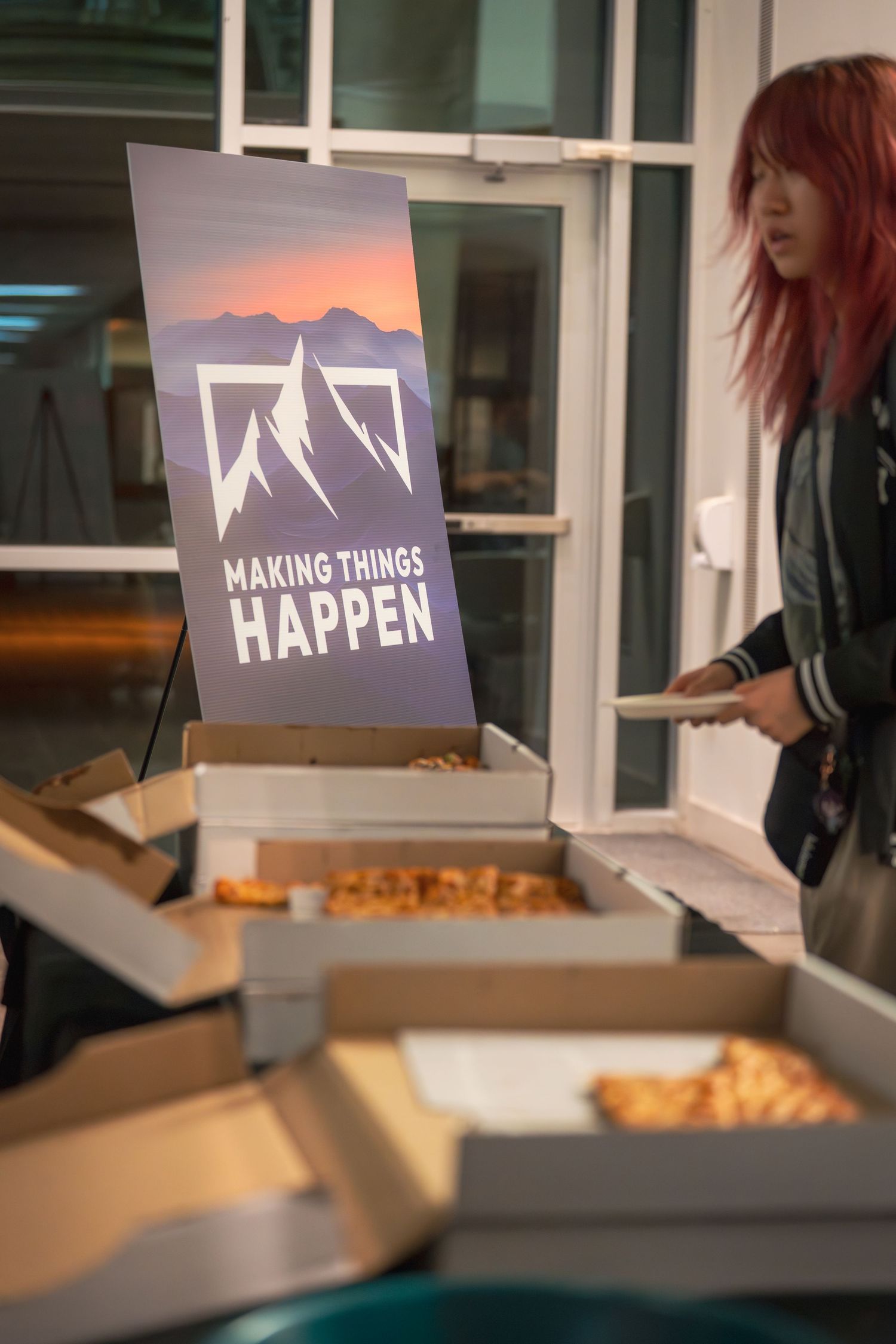 Event setup with food service tables and projection screen displaying 'Making Things Happen' logo.
