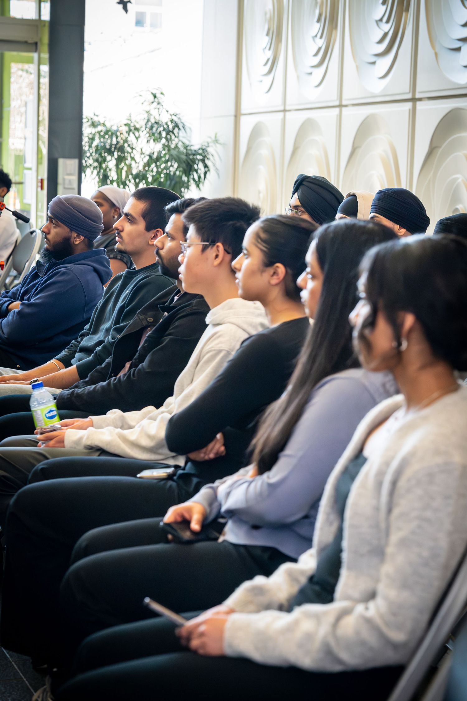 Audience members seated in rows watching attentively during a presentation or event.