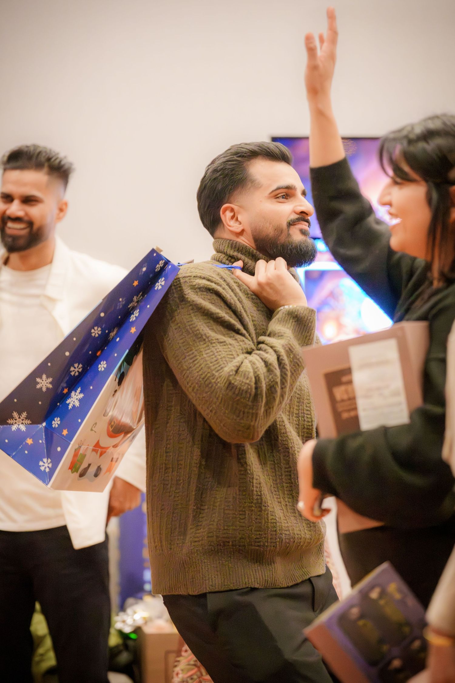 People celebrating with wrapped gifts and festive decorations at indoor party.