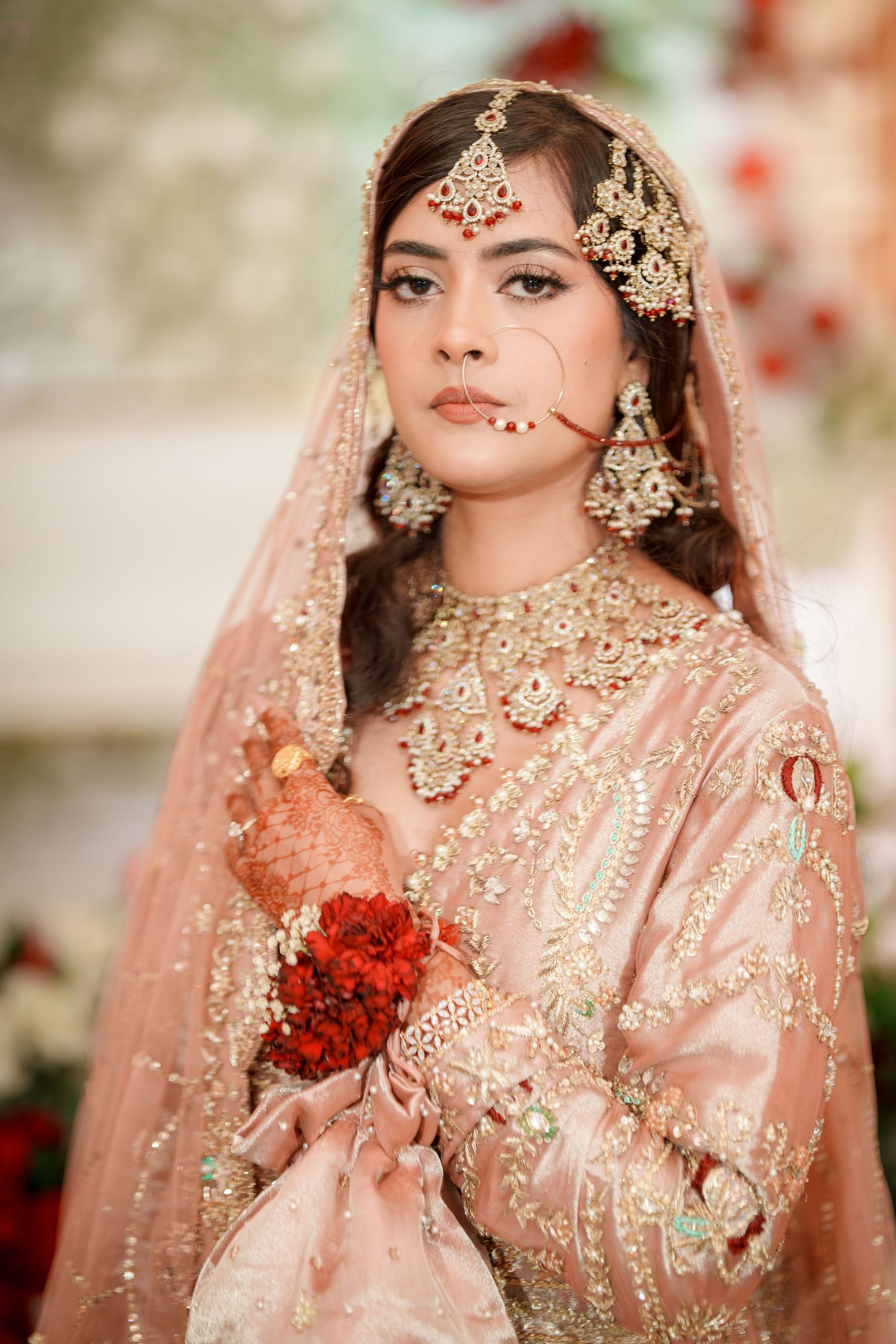 Traditional South Asian bridal portraits showcasing intricate peach and gold attire with jewelry.