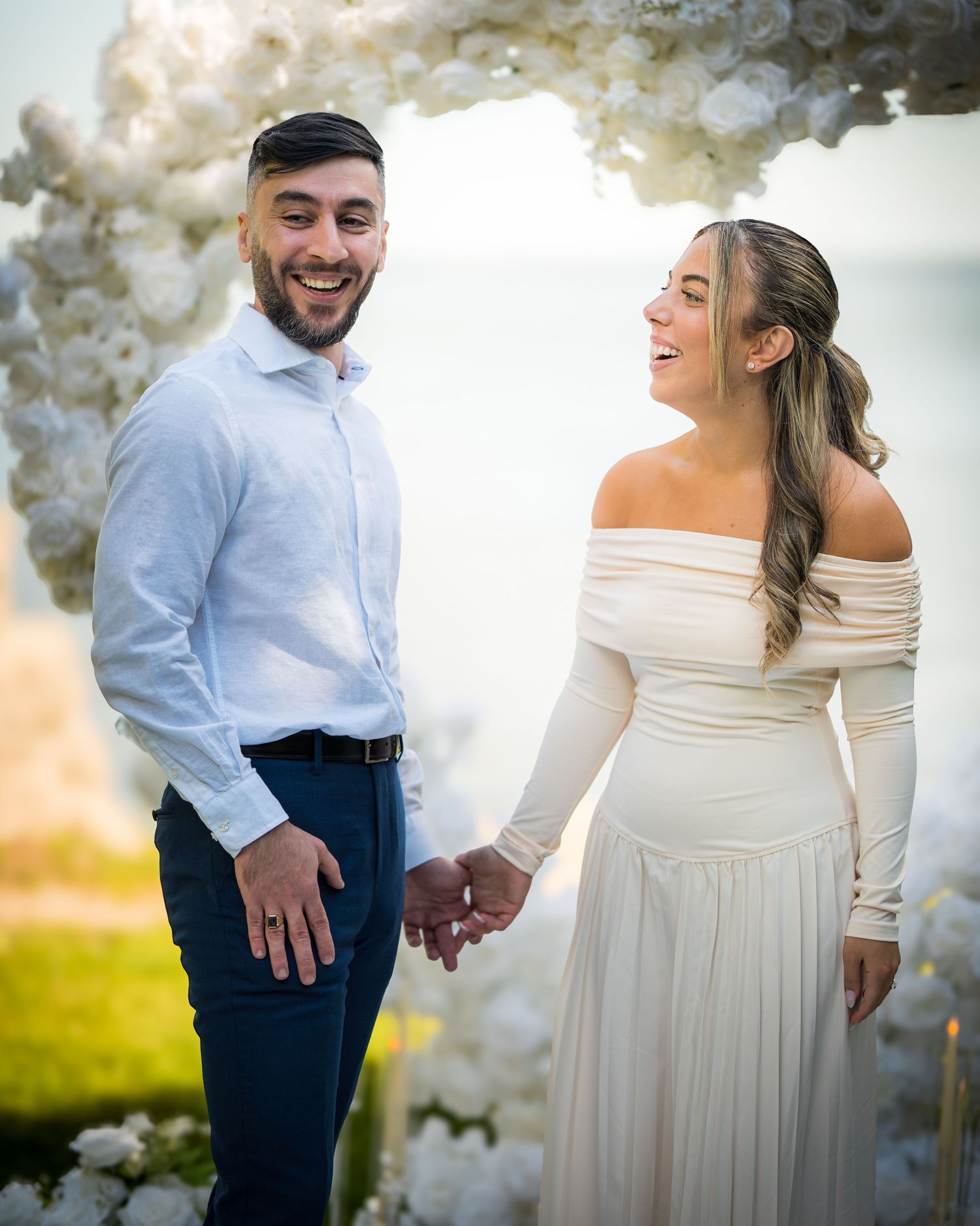 Candid moments of newlyweds dancing together under white floral arrangements.