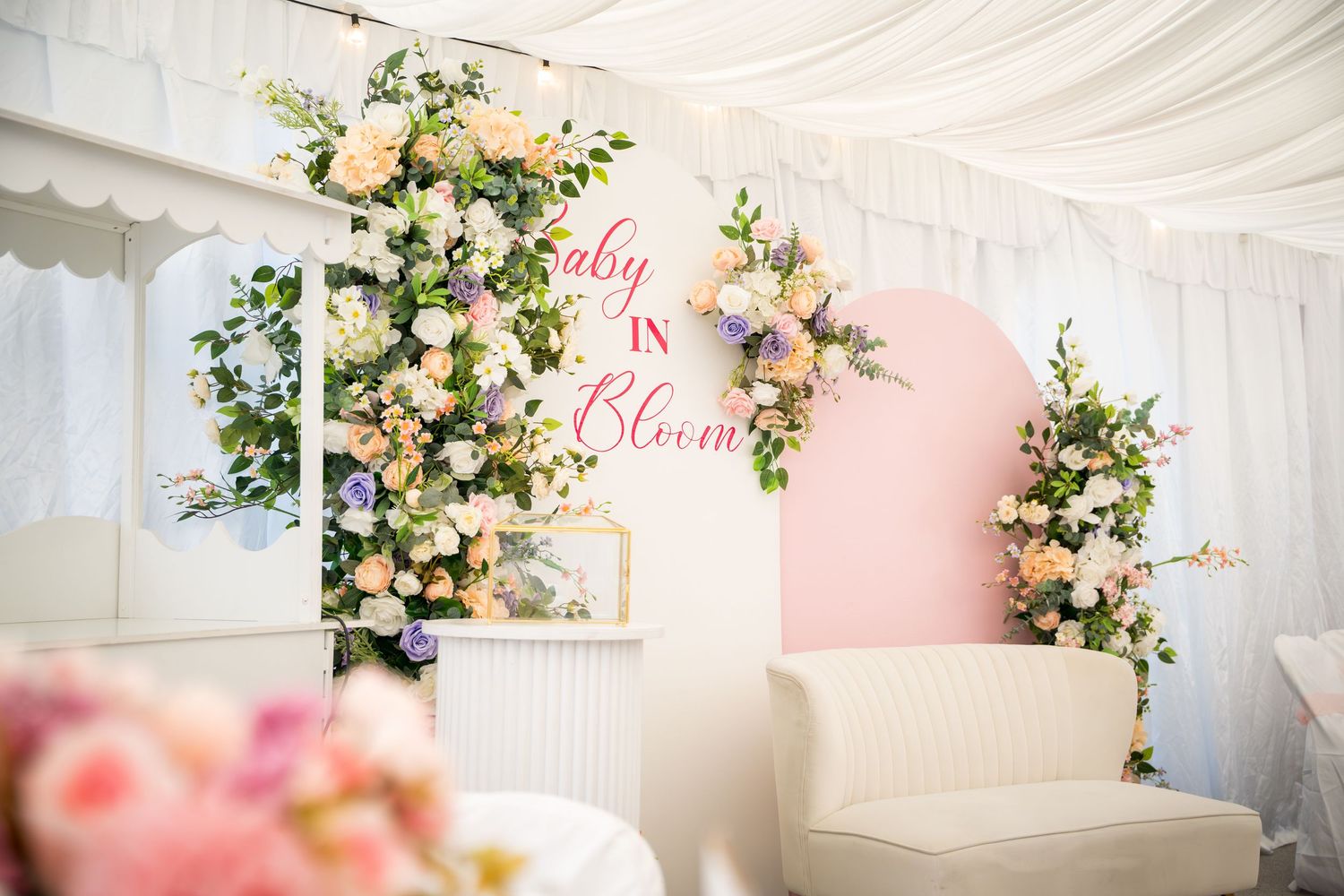 Romantic wedding decor featuring floral arrangements and soft white draping.
