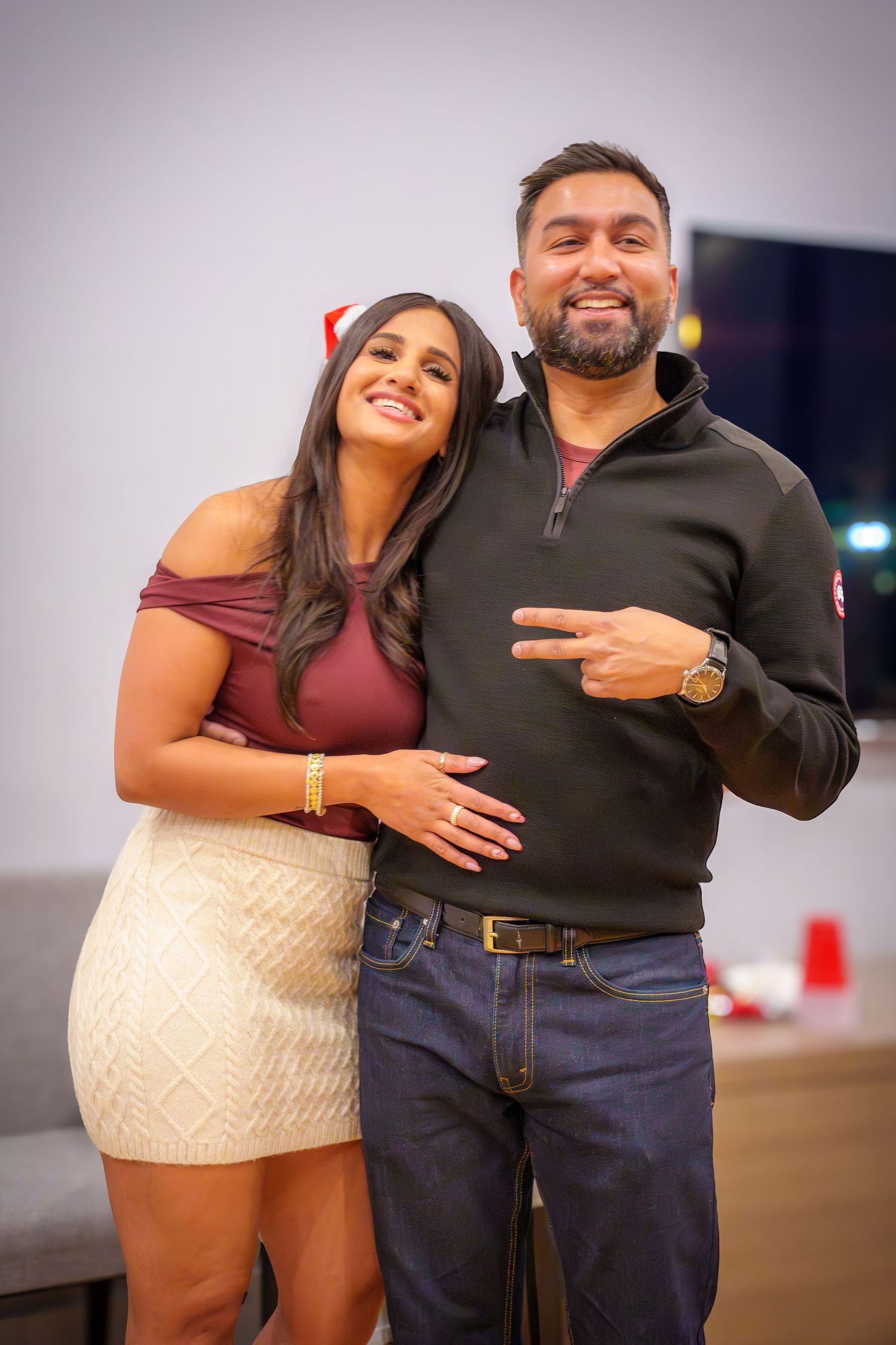 Two people posing together at a party with playful expressions.