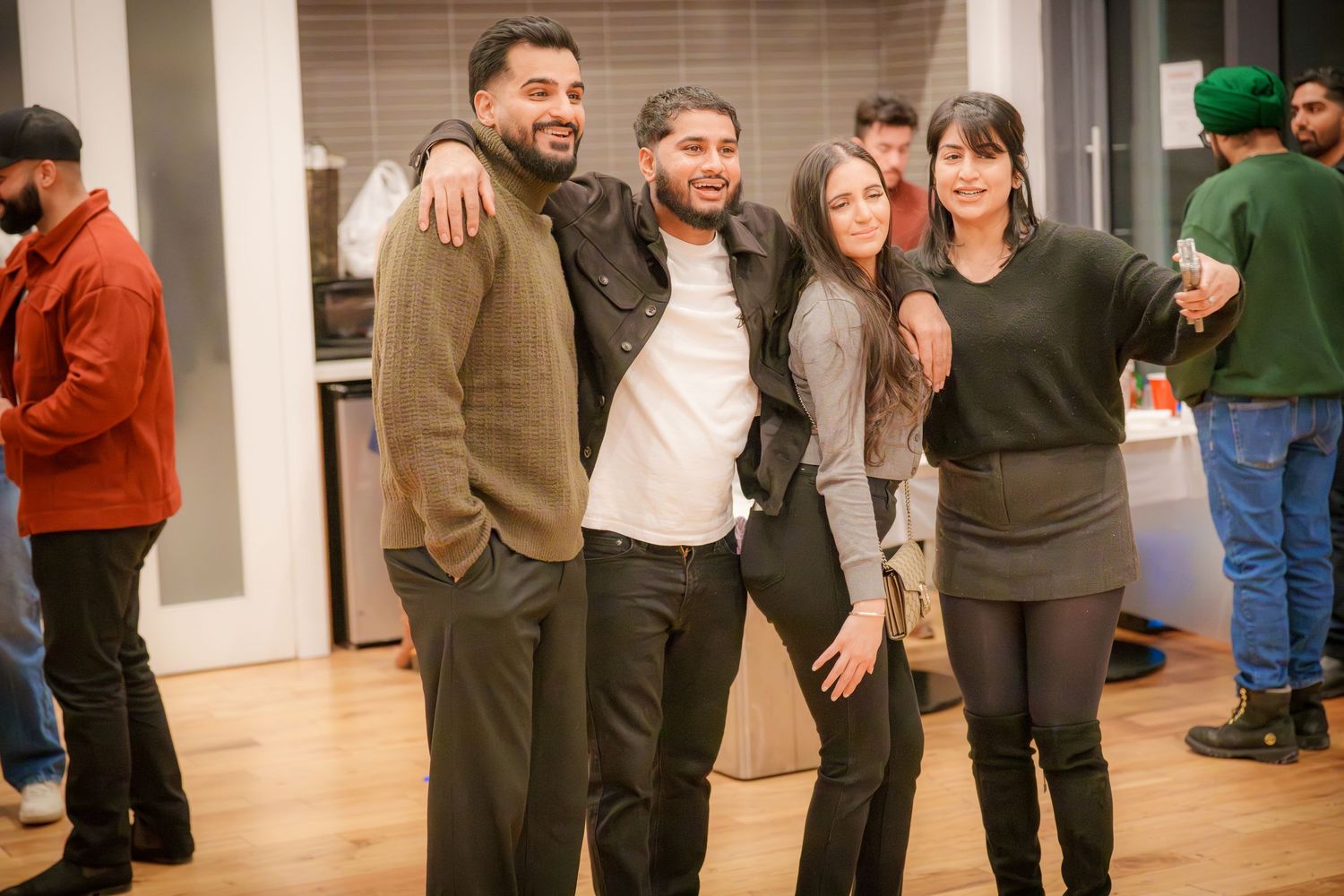 Large group of friends enjoying themselves at a casual indoor gathering.