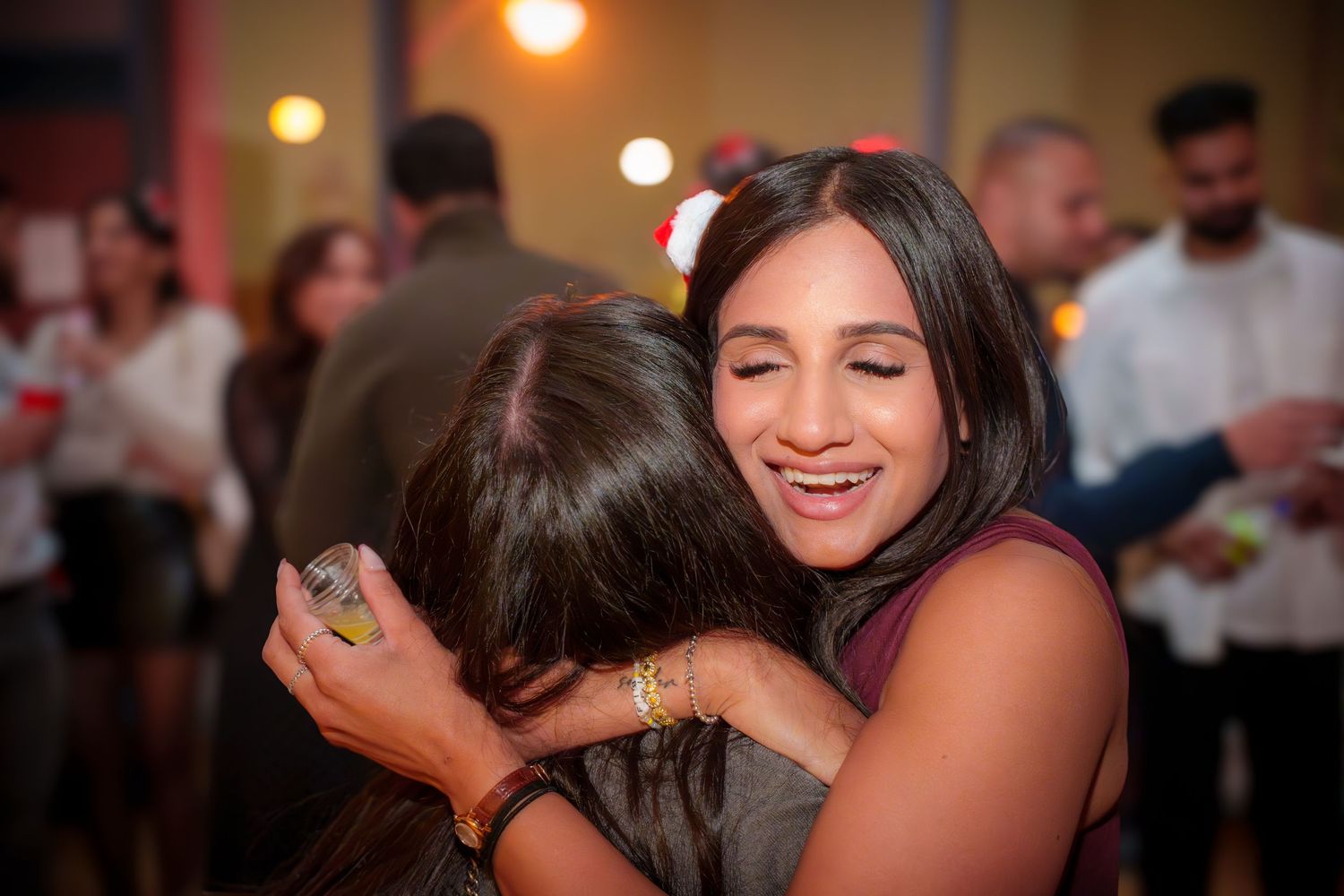 Partygoers laughing and having fun at an indoor social event.