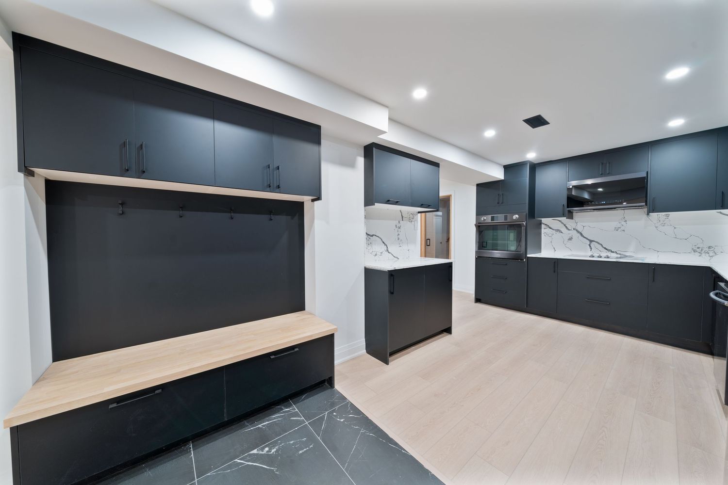 Modern basement renovation with sleek black walls and recessed lighting creates a contemporary living space.
