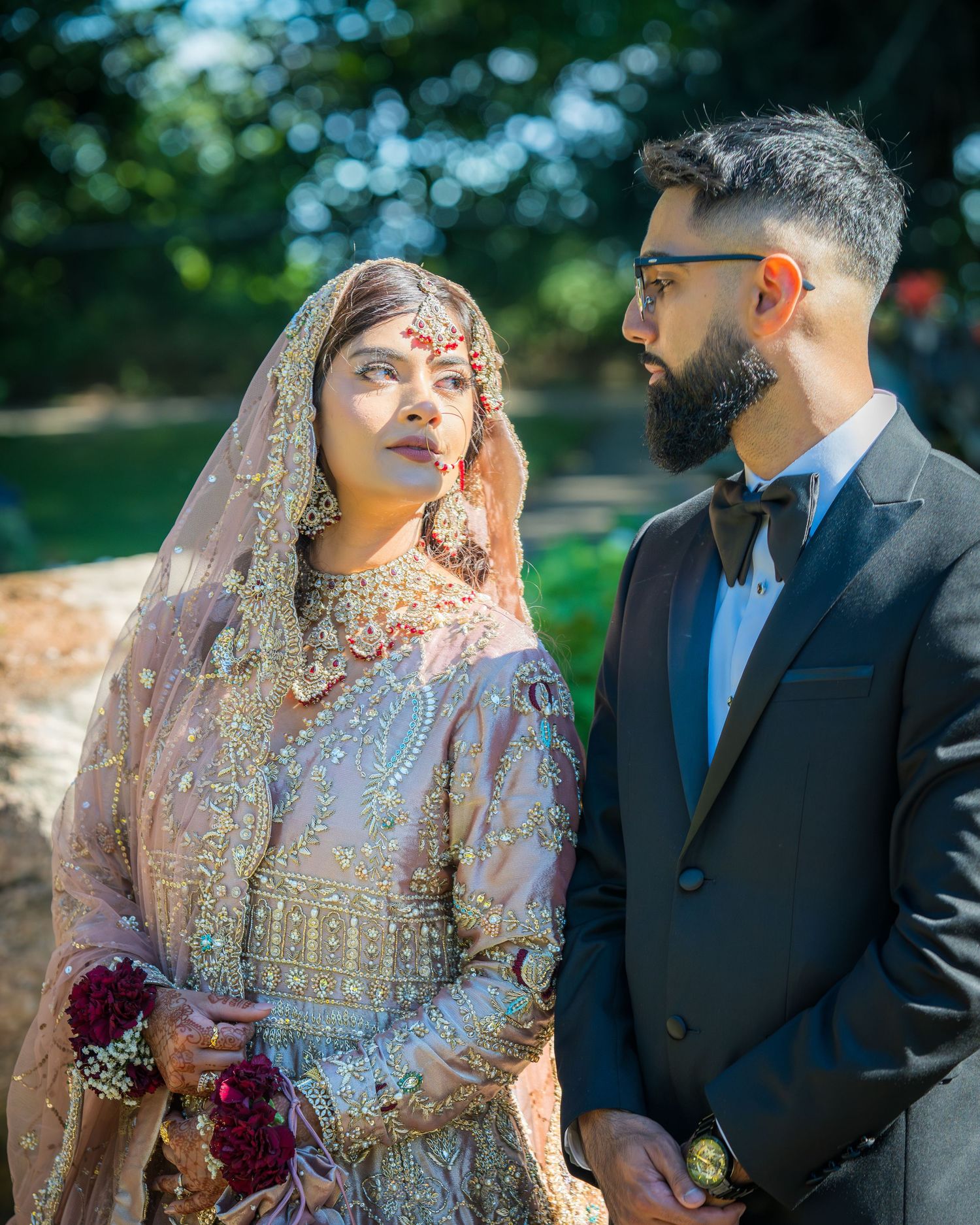 Elegant wedding portraits in a garden setting with soft natural lighting and lush foliage.