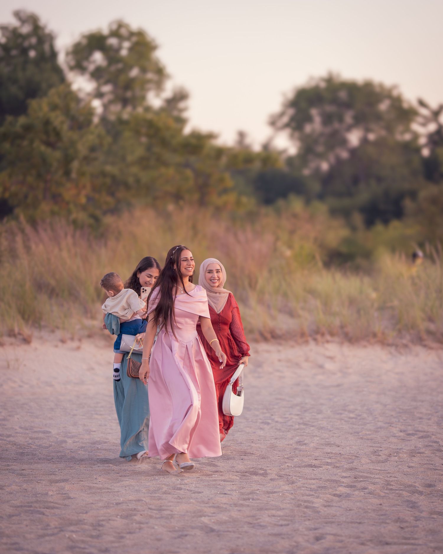 Beachside gathering with people walking on sandy shore at dusk.