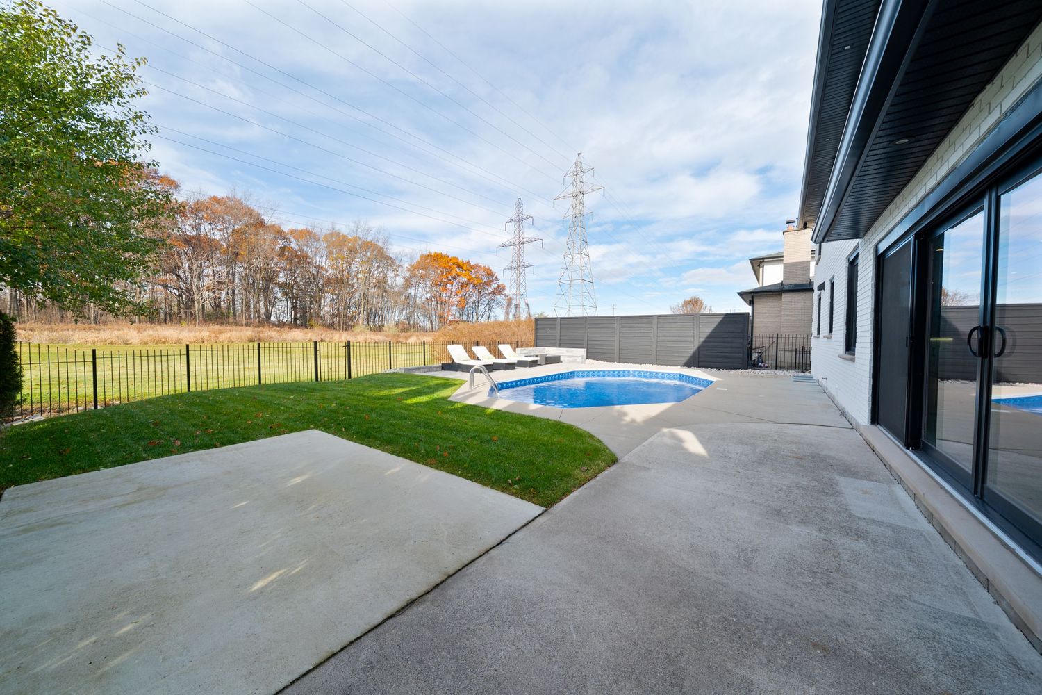 Panoramic view of a modern residential rooftop deck with glass railings and mountain views in the background.