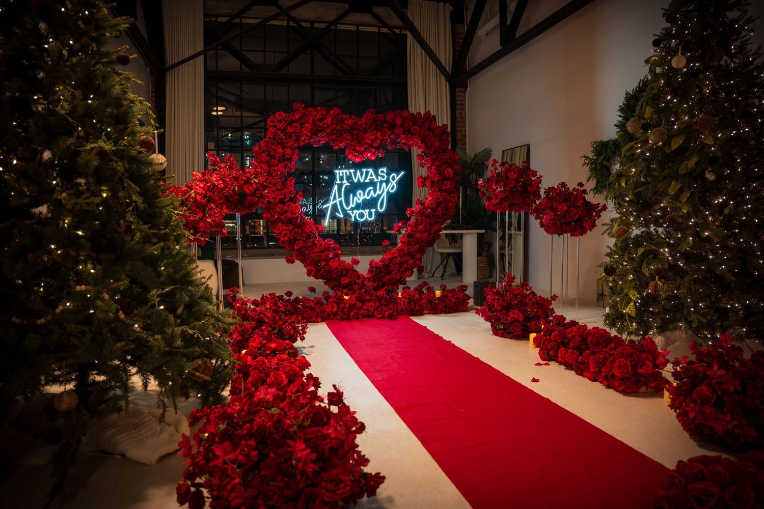 A stunning red carpet pathway lined with rose arrangements and twinkling lights.