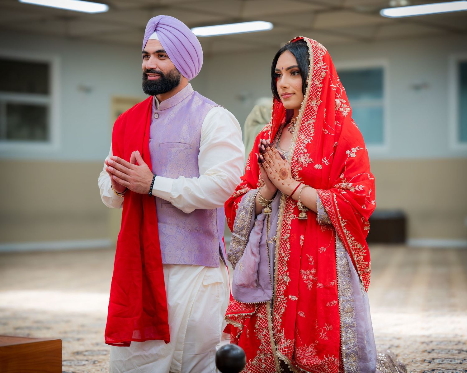 Traditional Punjabi wedding photoshoot in indoor setting with elegant outfits.