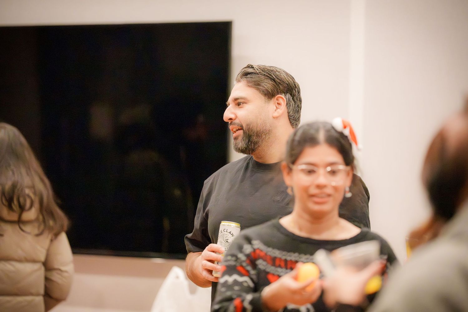 Social event with people chatting and mingling in a modern indoor space.