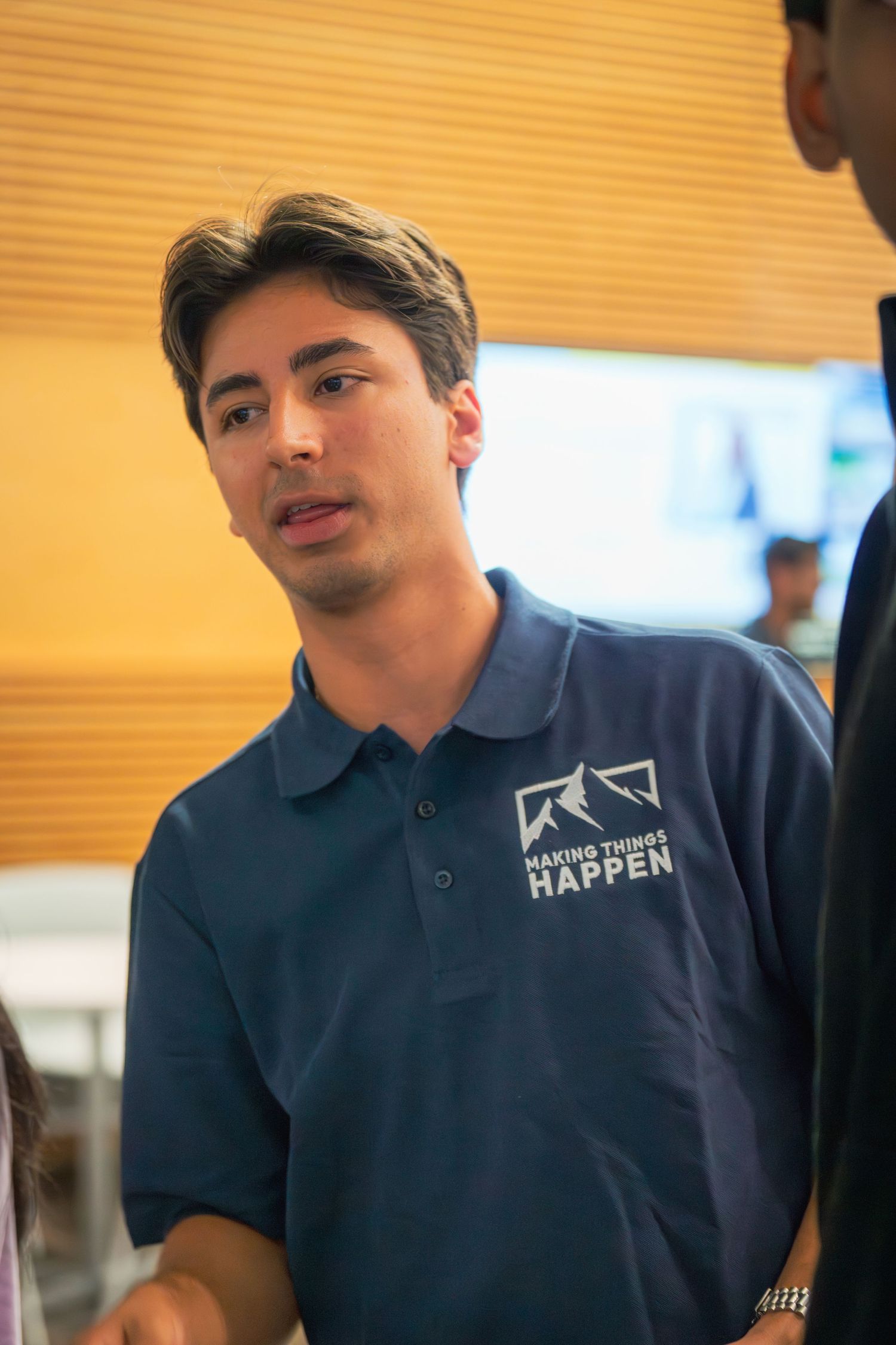 Close-up view of navy blue polo shirt with embroidered logo.