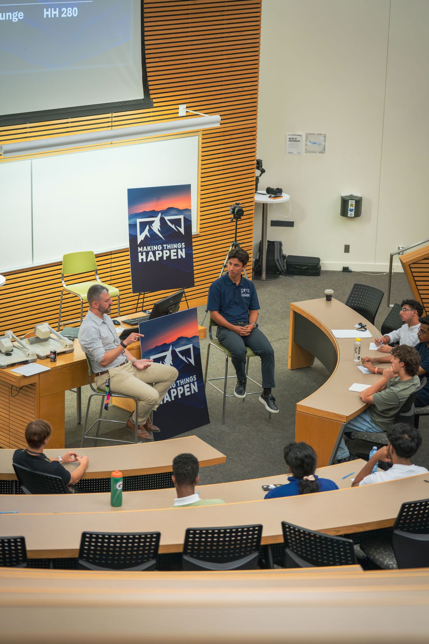 Wide angle view of a classroom discussion setup with chairs and presentation materials.
