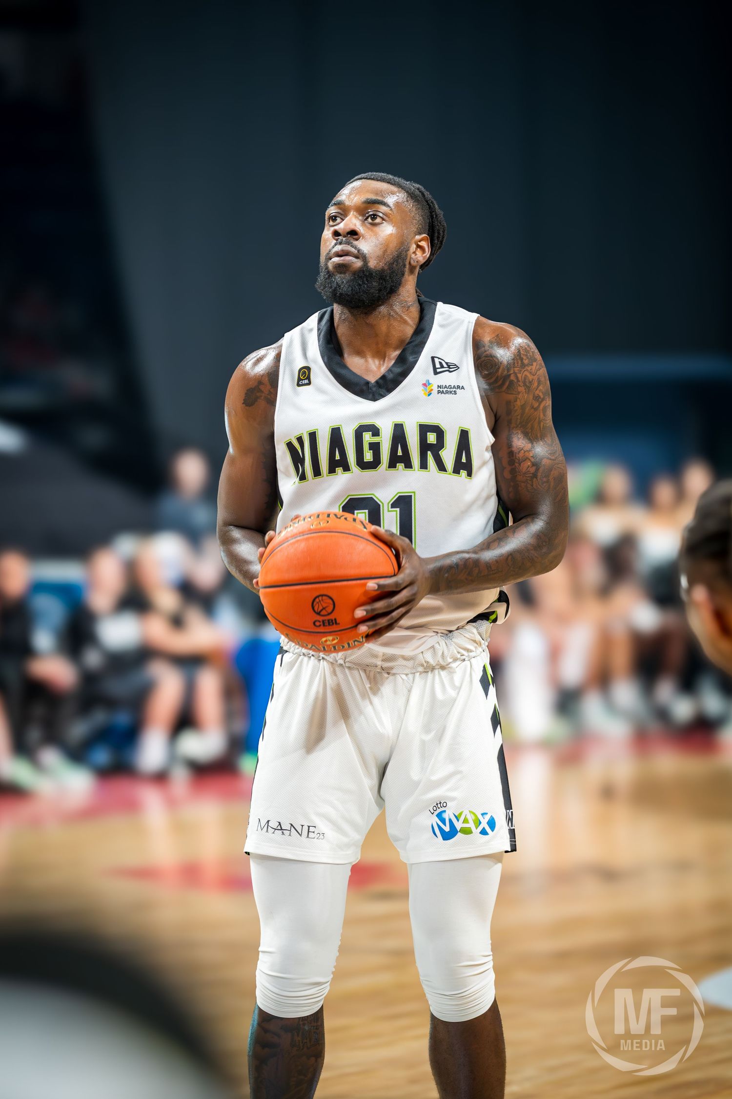 Niagara River Lions player #21 focuses at the free throw line holding a basketball during a CEBL game.