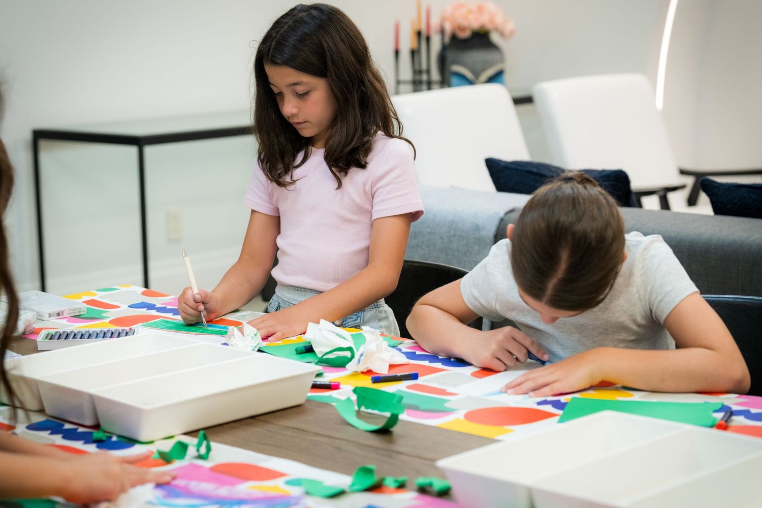 Two children focus on painting and drawing during a colorful hands-on art class.